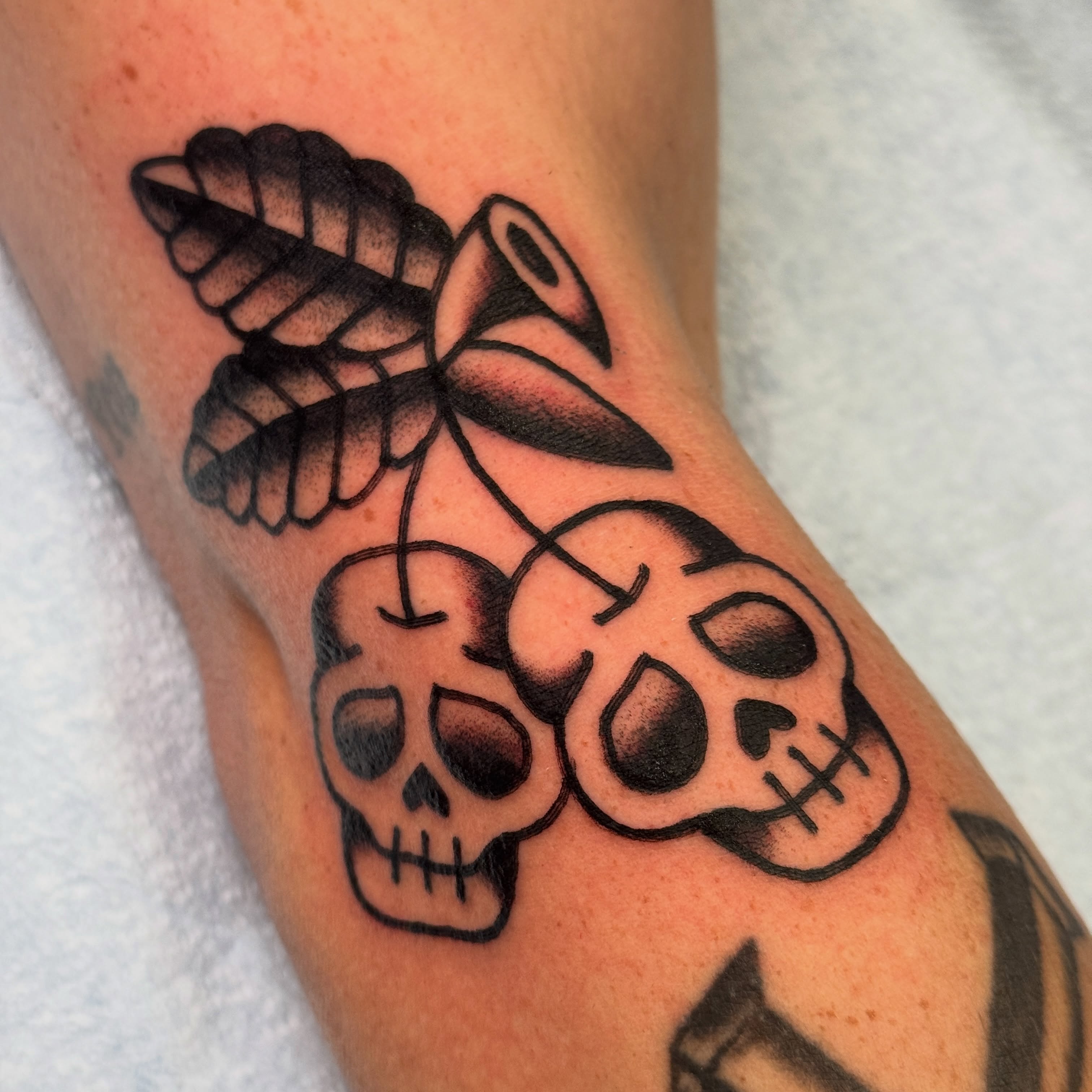 Skulls and trumpet black and grey tattoo on the forearm by Rafael Torres, San Francisco, California