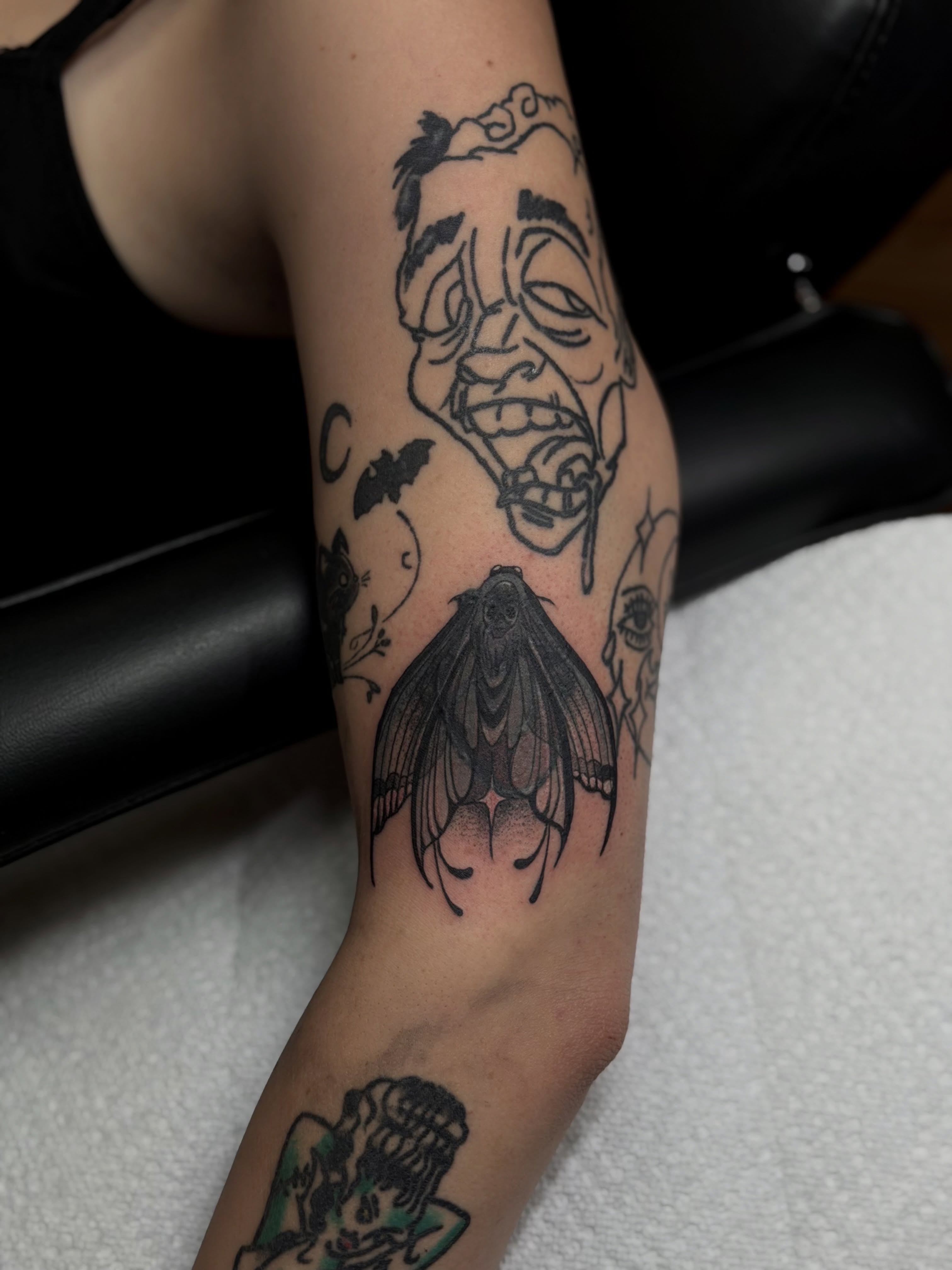 Masks and moth realism tattoo on the forearm by Skylar Sheeley