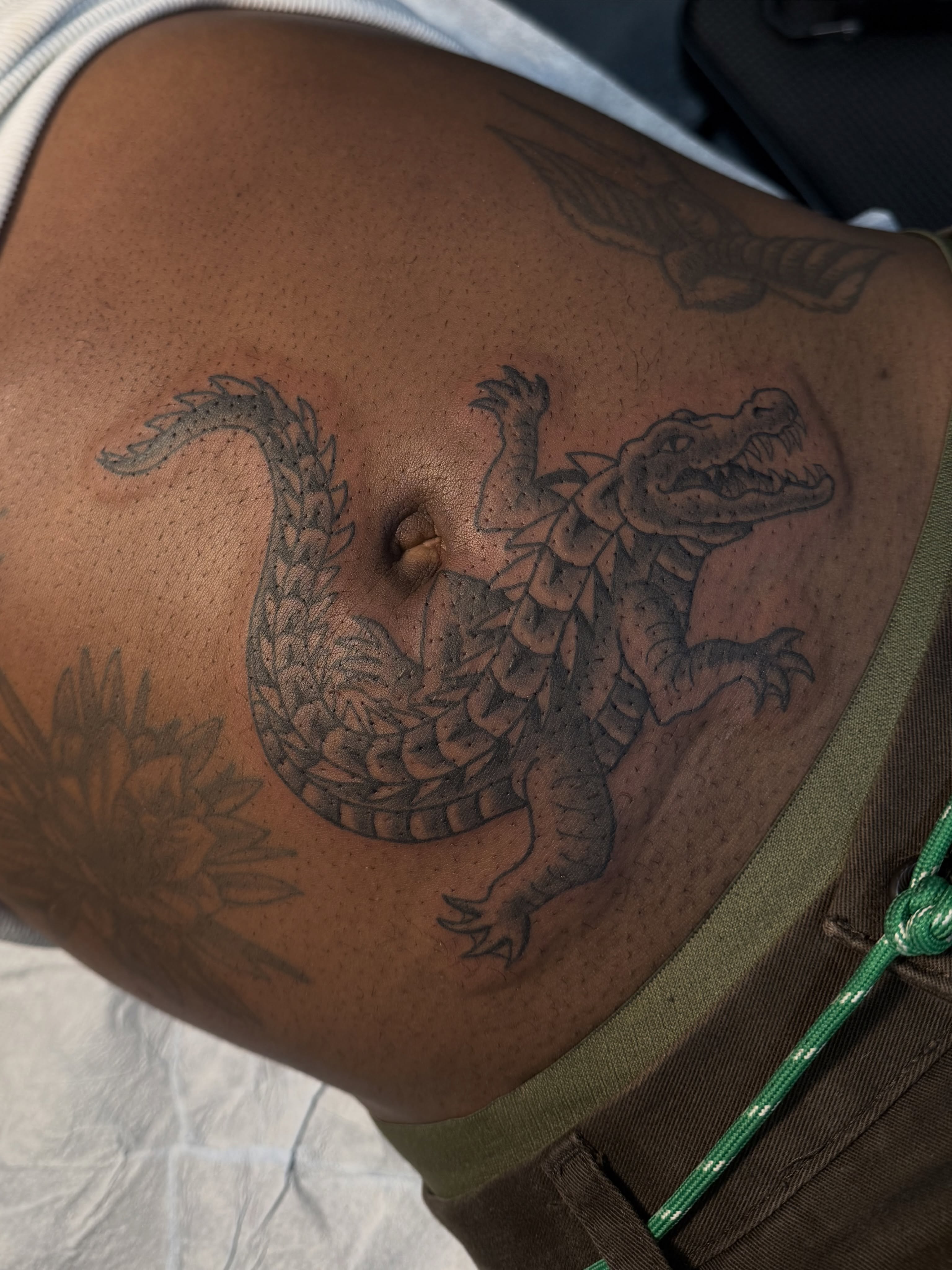 Alligator black and grey tattoo on the thigh by Devin Derbes