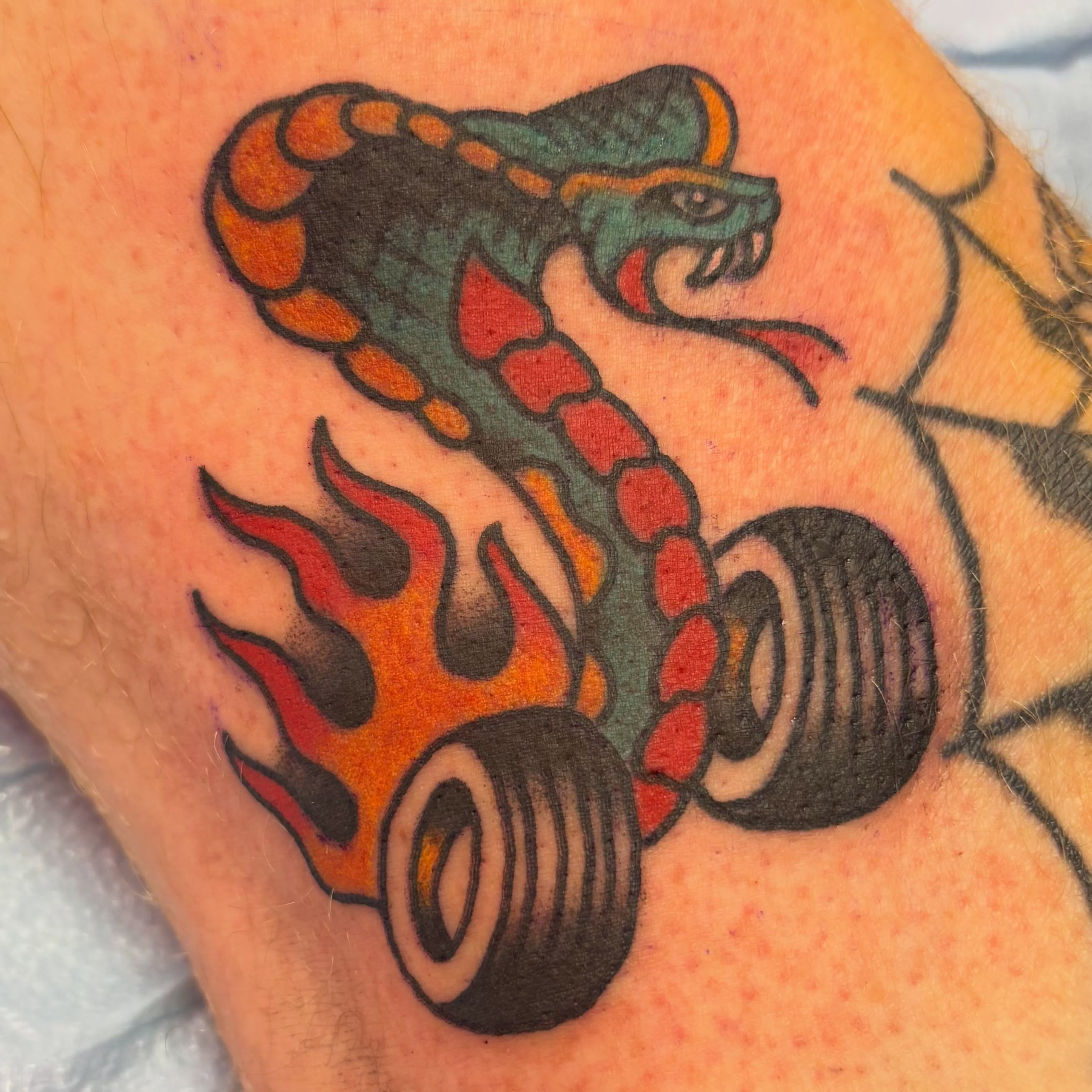 Snake with wheels American traditional tattoo on the forearm by @dannydoestattoos