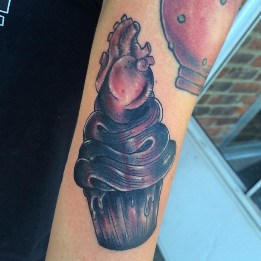 Heart-shaped cupcake realism tattoo on the forearm by Vudu Tattooer