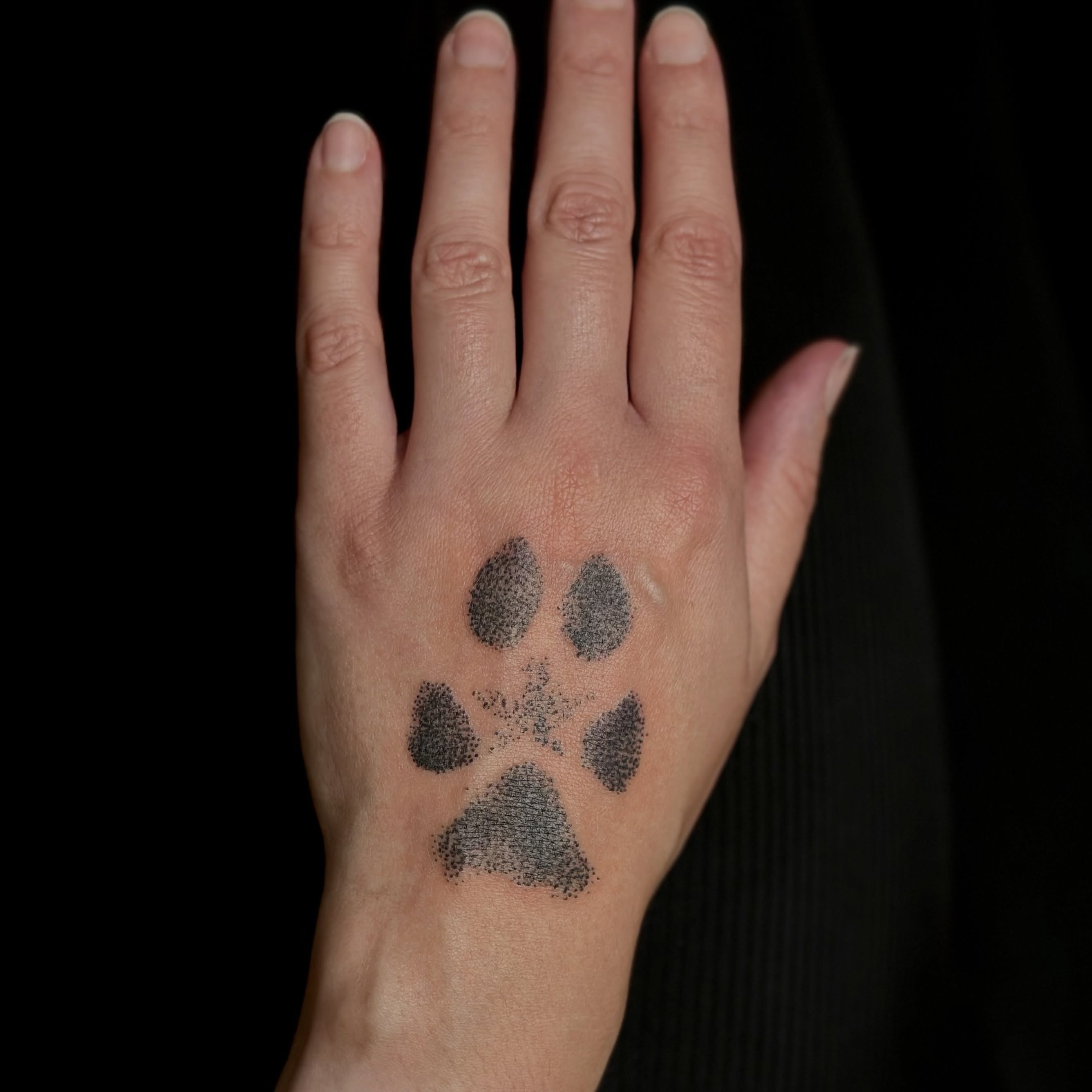 Paw print dotwork tattoo on the hand by Zoe Arrigo