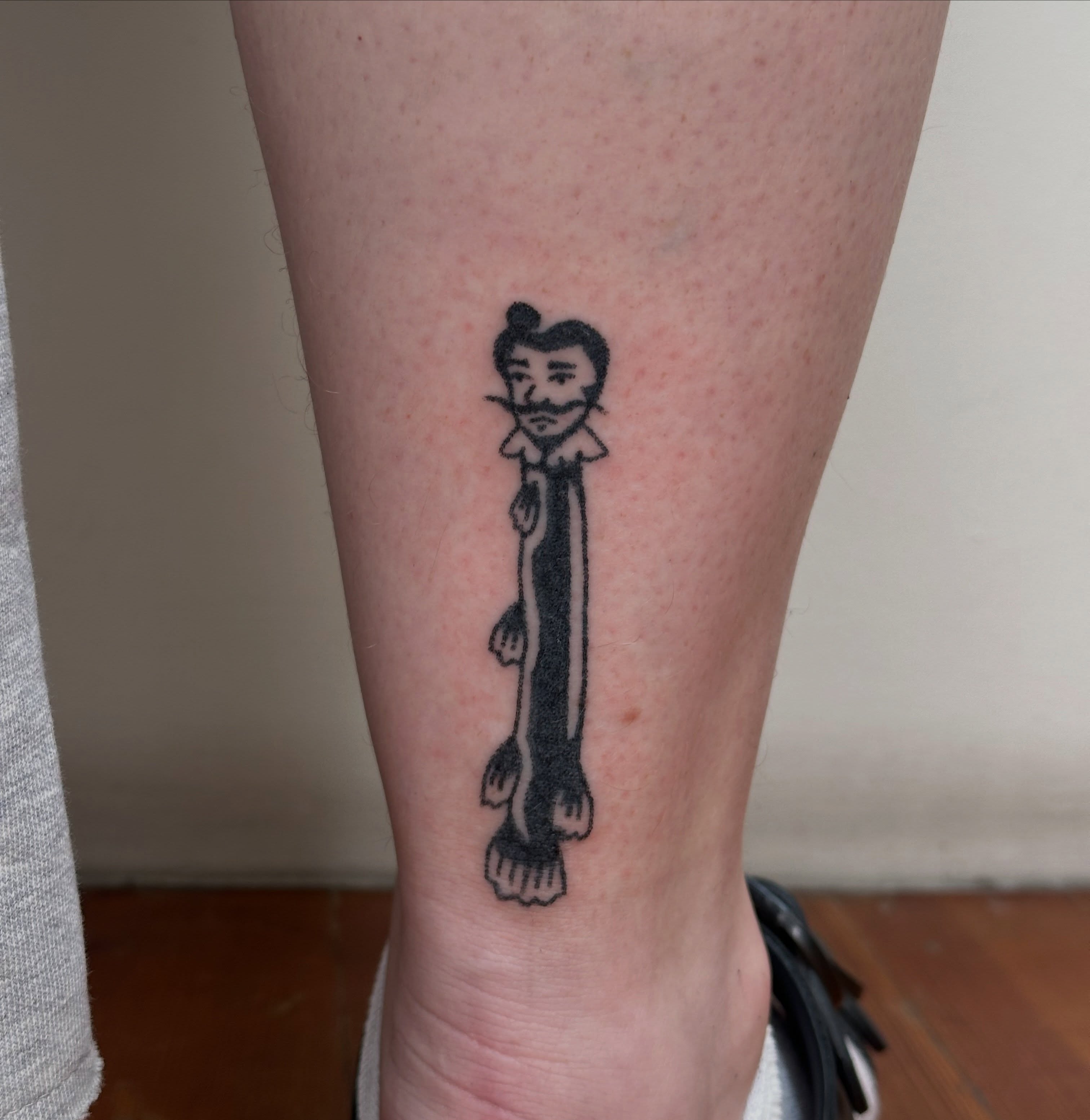 Man with ruffled collar black and grey tattoo on the calf by paulina