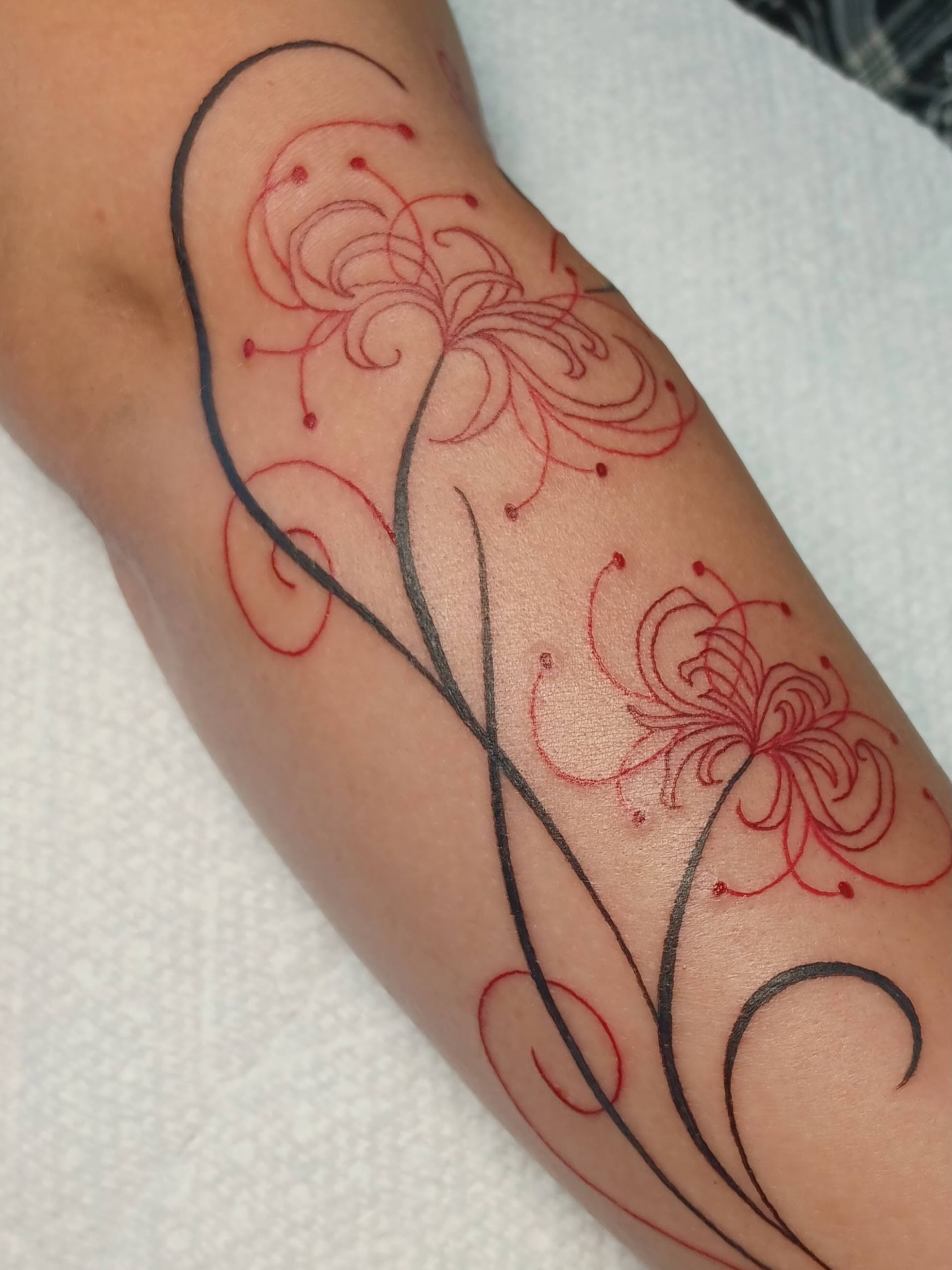 Floral design fine line tattoo on the forearm by Abi