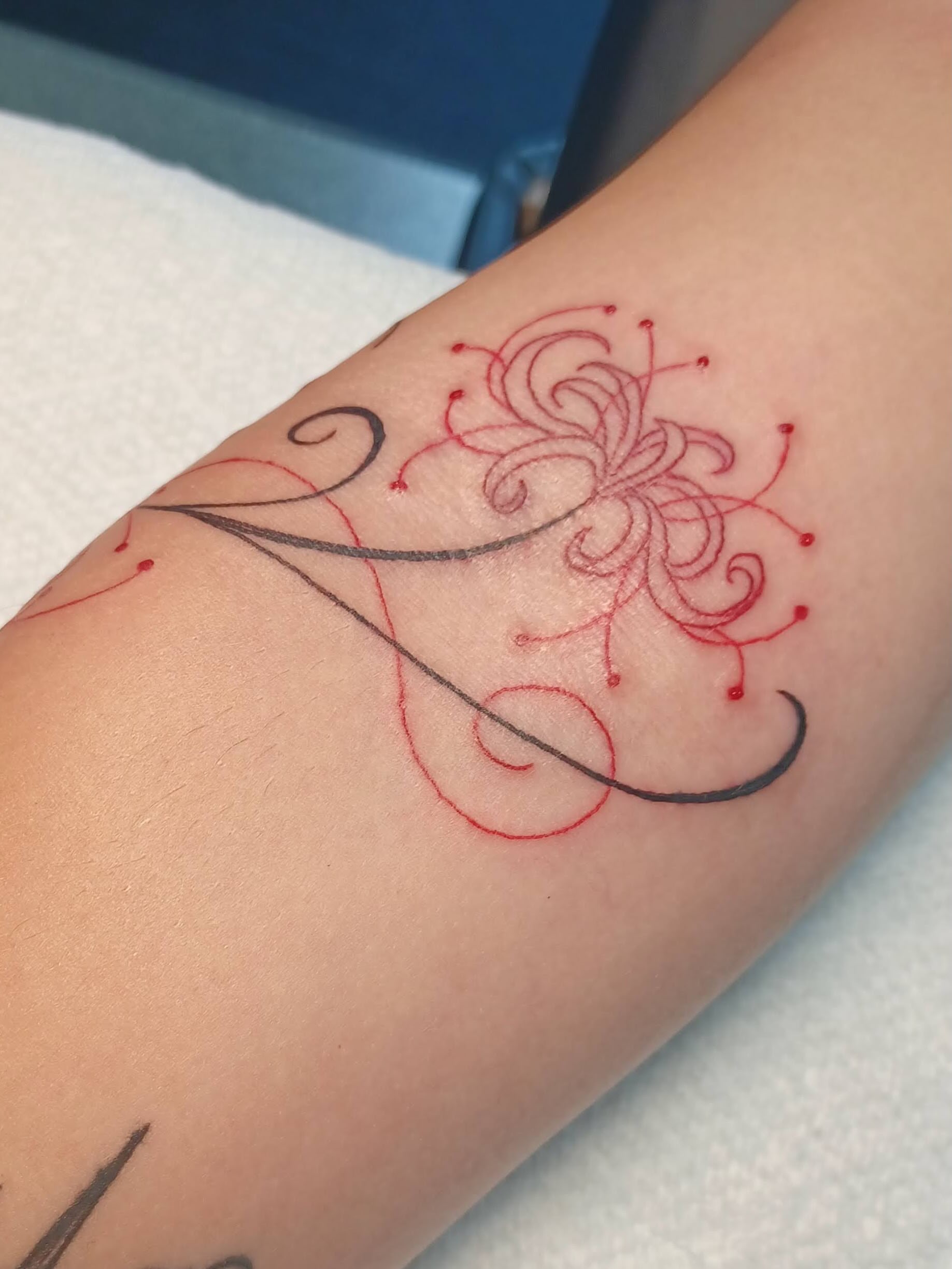 Floral design fine line tattoo on the forearm by Abi