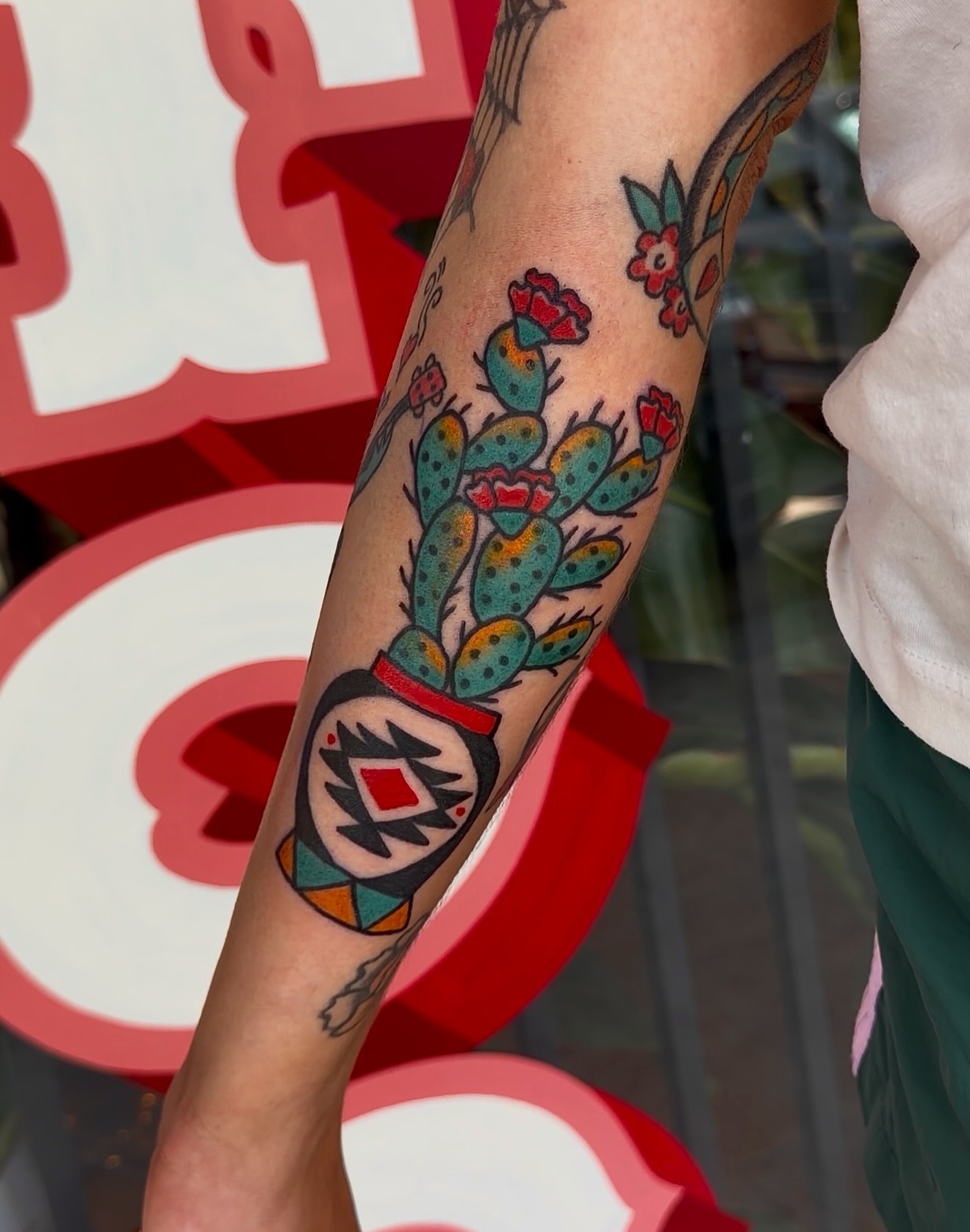 Cactus and flowers American traditional tattoo on the forearm by Myka King