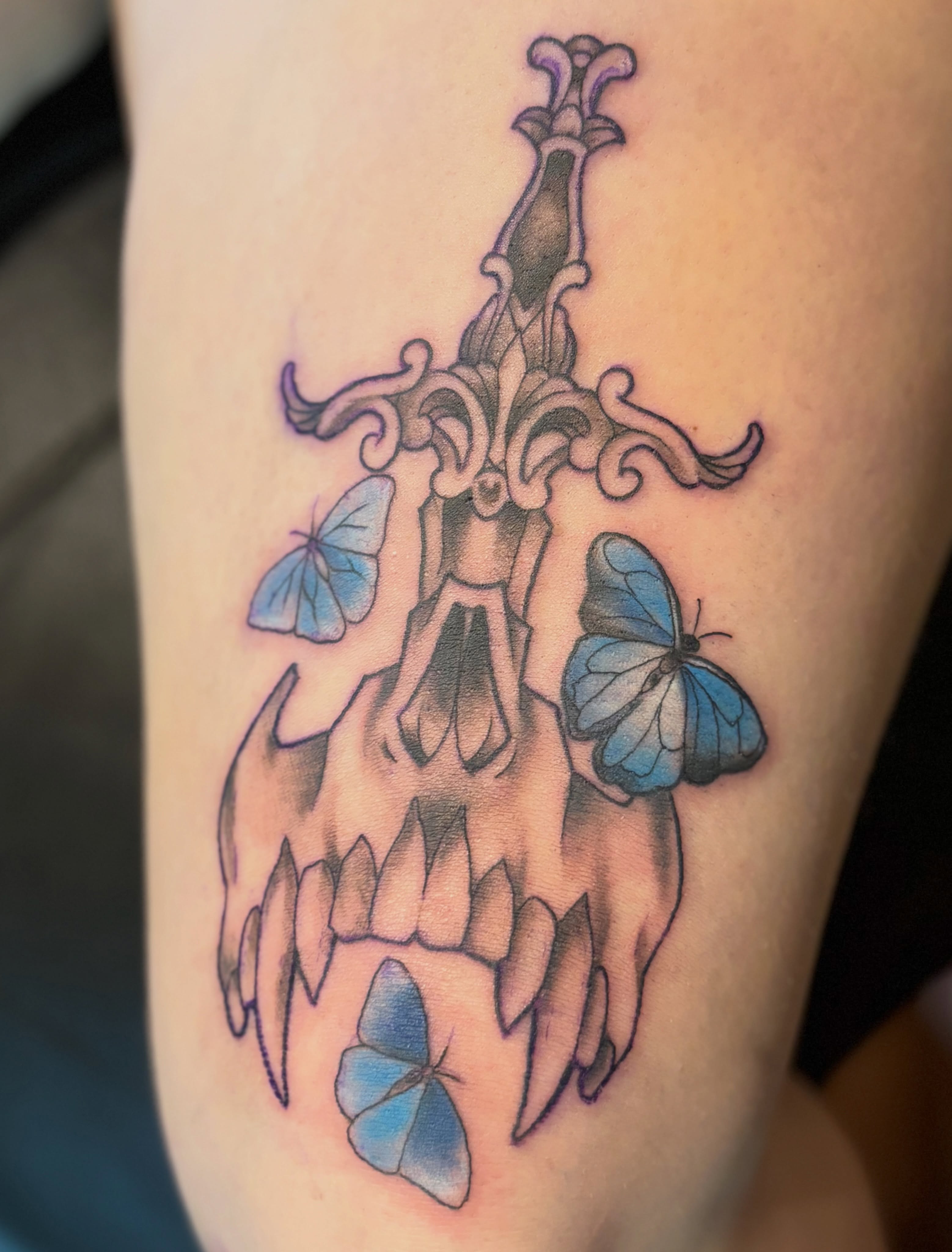 Skull with sword and butterflies neo-traditional tattoo on the forearm by Komfort Kristy