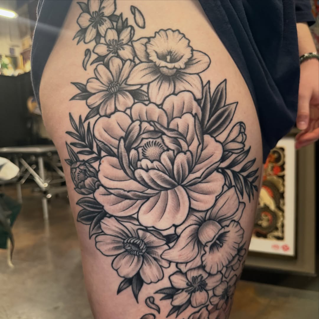 Floral bouquet black and grey tattoo on the thigh by Christopher Mikesell