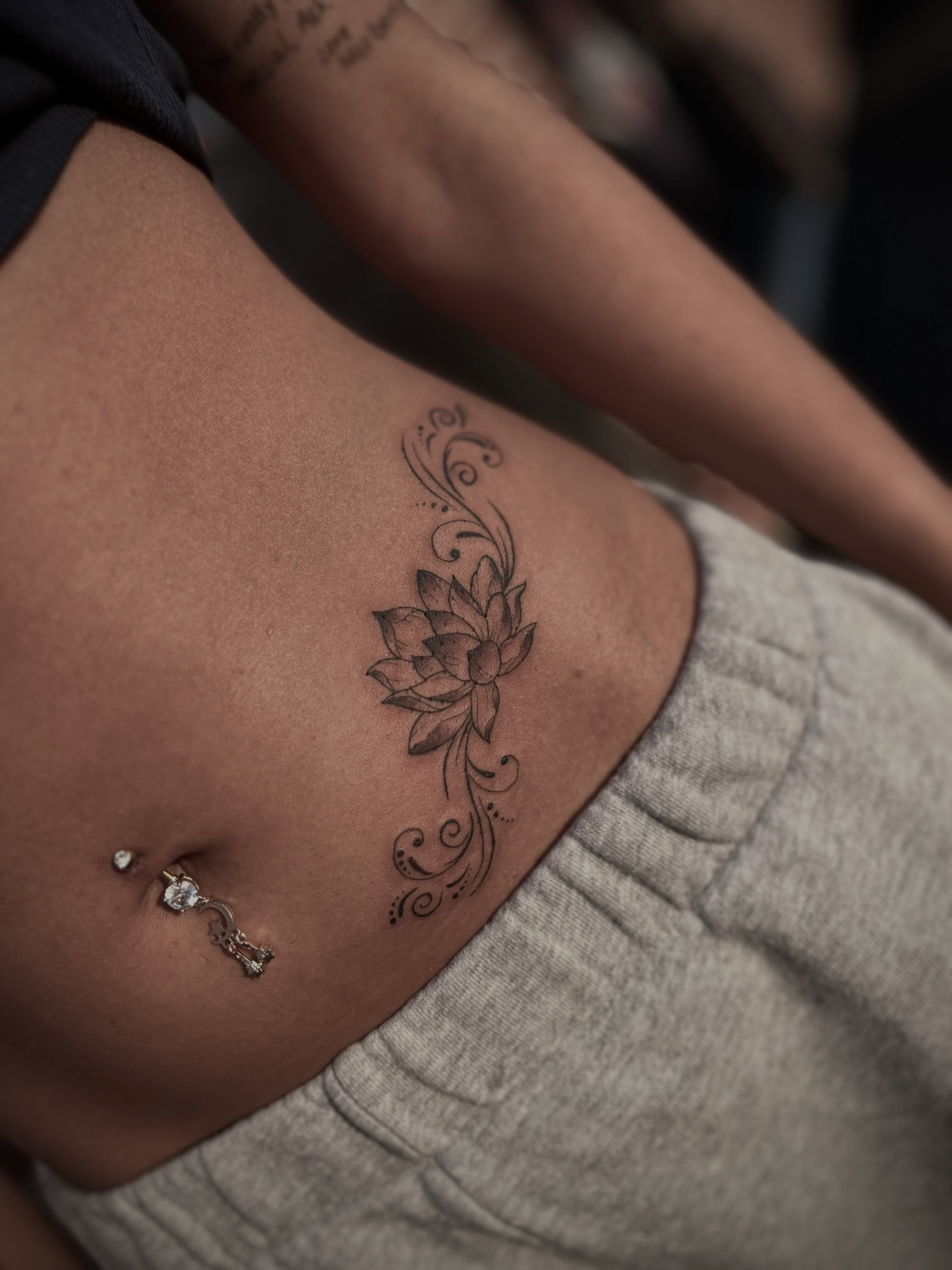 Lotus flower black and grey tattoo on the ribs by Lexi Rose