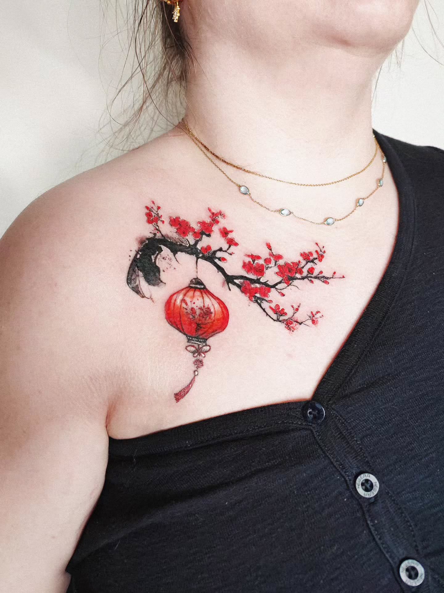 Cherry blossoms and lantern watercolor tattoo on the chest by 𝗔𝗟𝗘𝗫 𝗣𝗥𝗘𝗤𝗨𝗘𝗟 𝗧𝗔𝗧𝗧𝗢𝗢𝗦 𝗖𝗛𝗜𝗖𝗔𝗚𝗢 ™, Chicago, Illinois