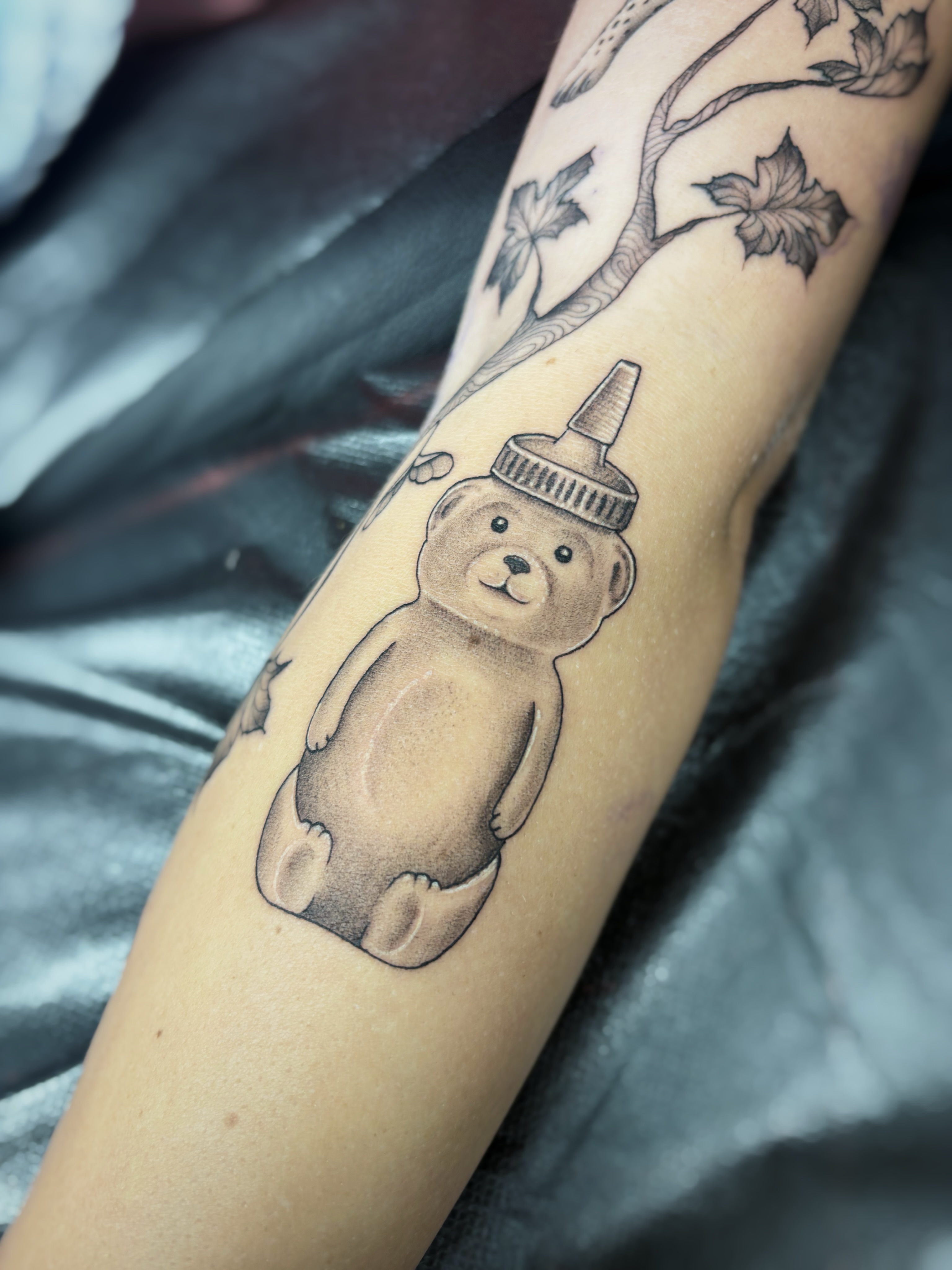 Teddy bear black and grey tattoo on the forearm by Fine Line Tattoo Artist