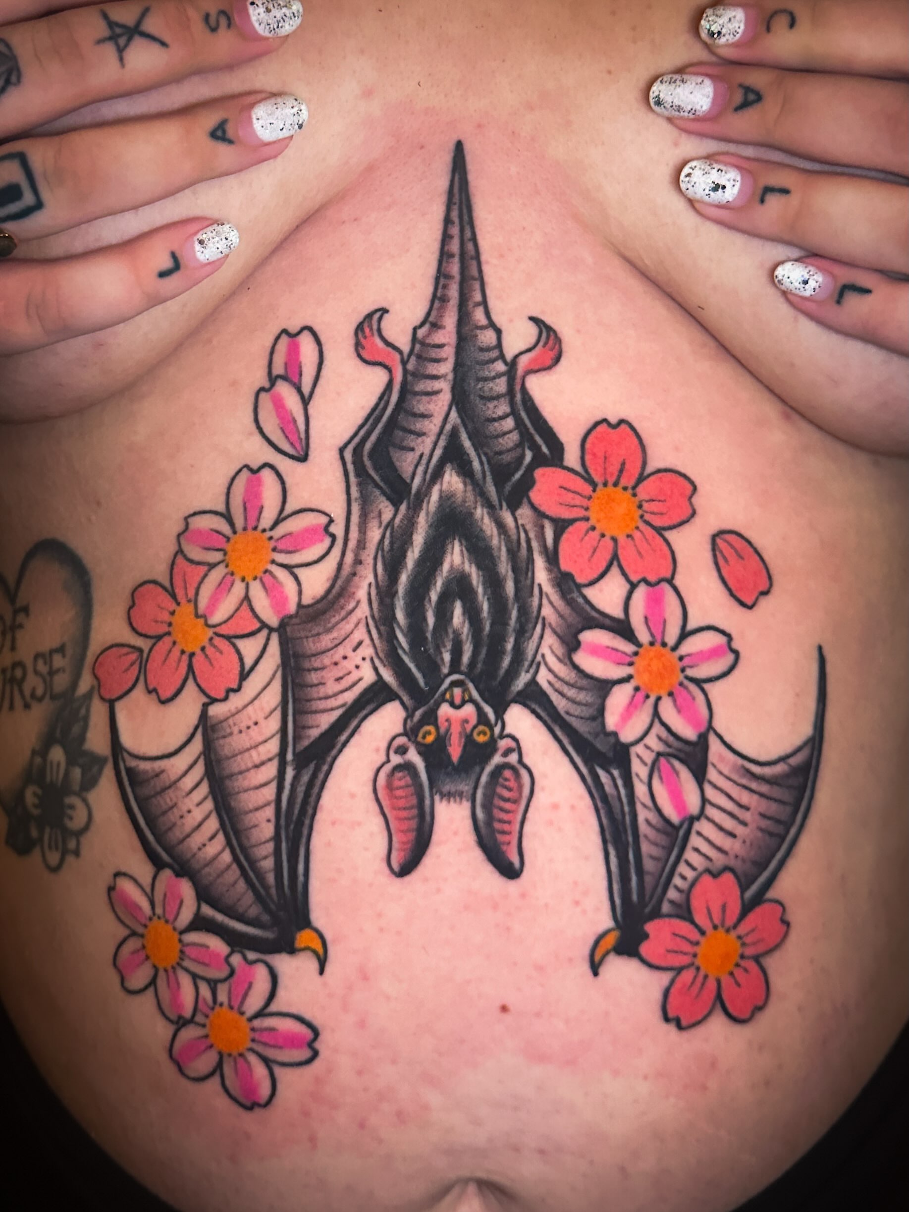 Bat and flowers American traditional tattoo on the chest by Stacey Colangelo