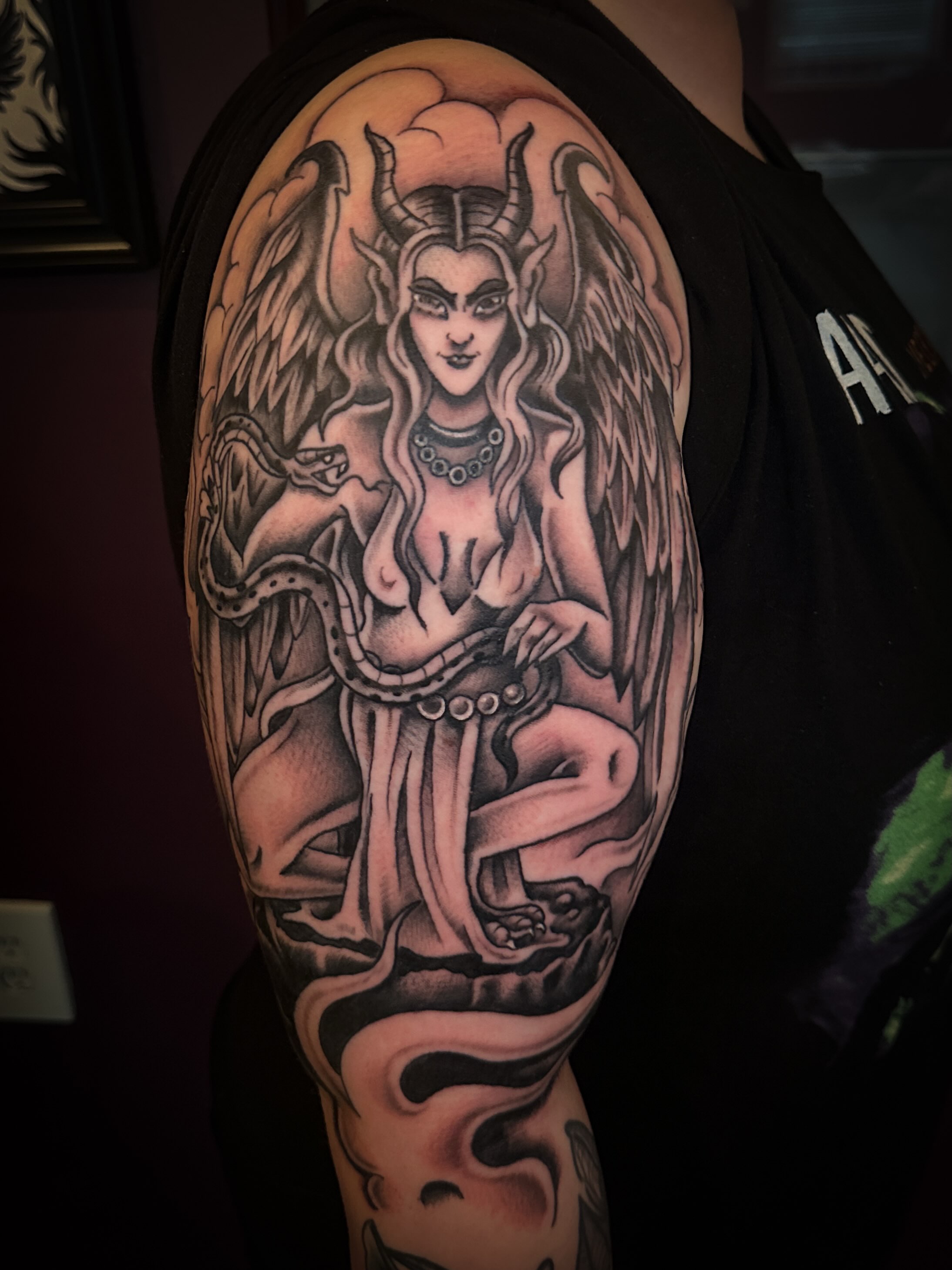Winged female figure realism tattoo on the upper arm by Stacey Colangelo