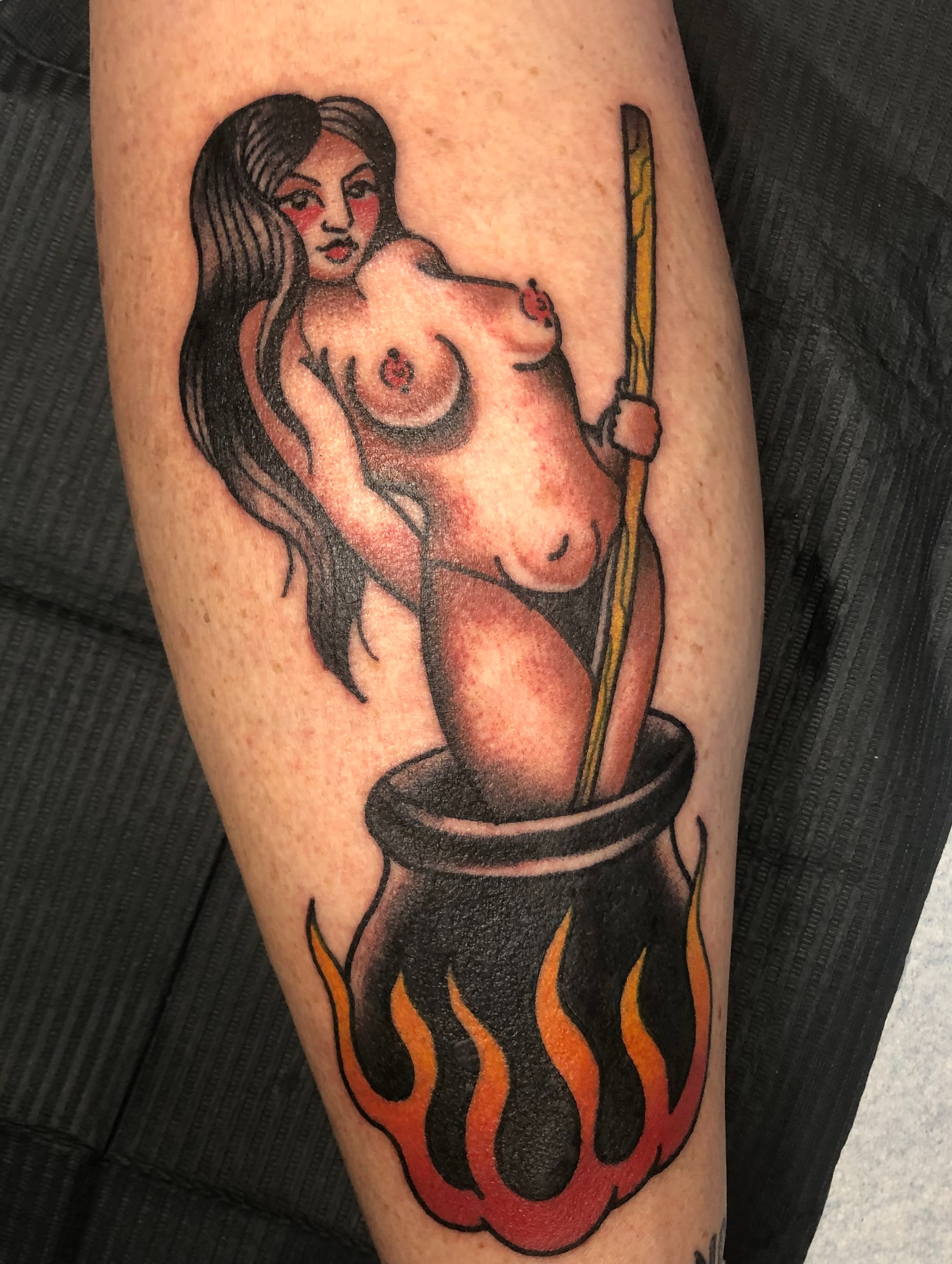 Naked woman in cauldron American traditional tattoo on the forearm by Stacey Colangelo