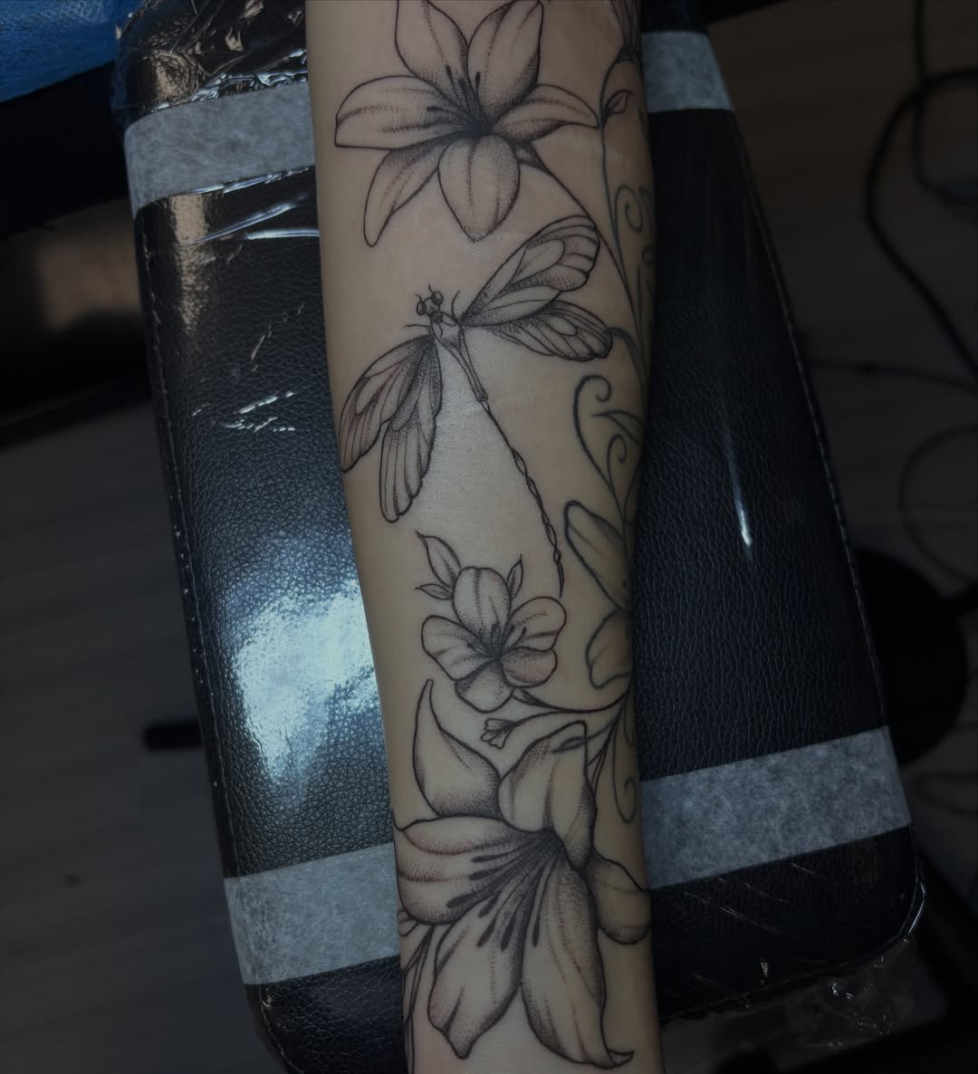 Lily and dragonfly realism tattoo on the forearm by Sydney Gallucci