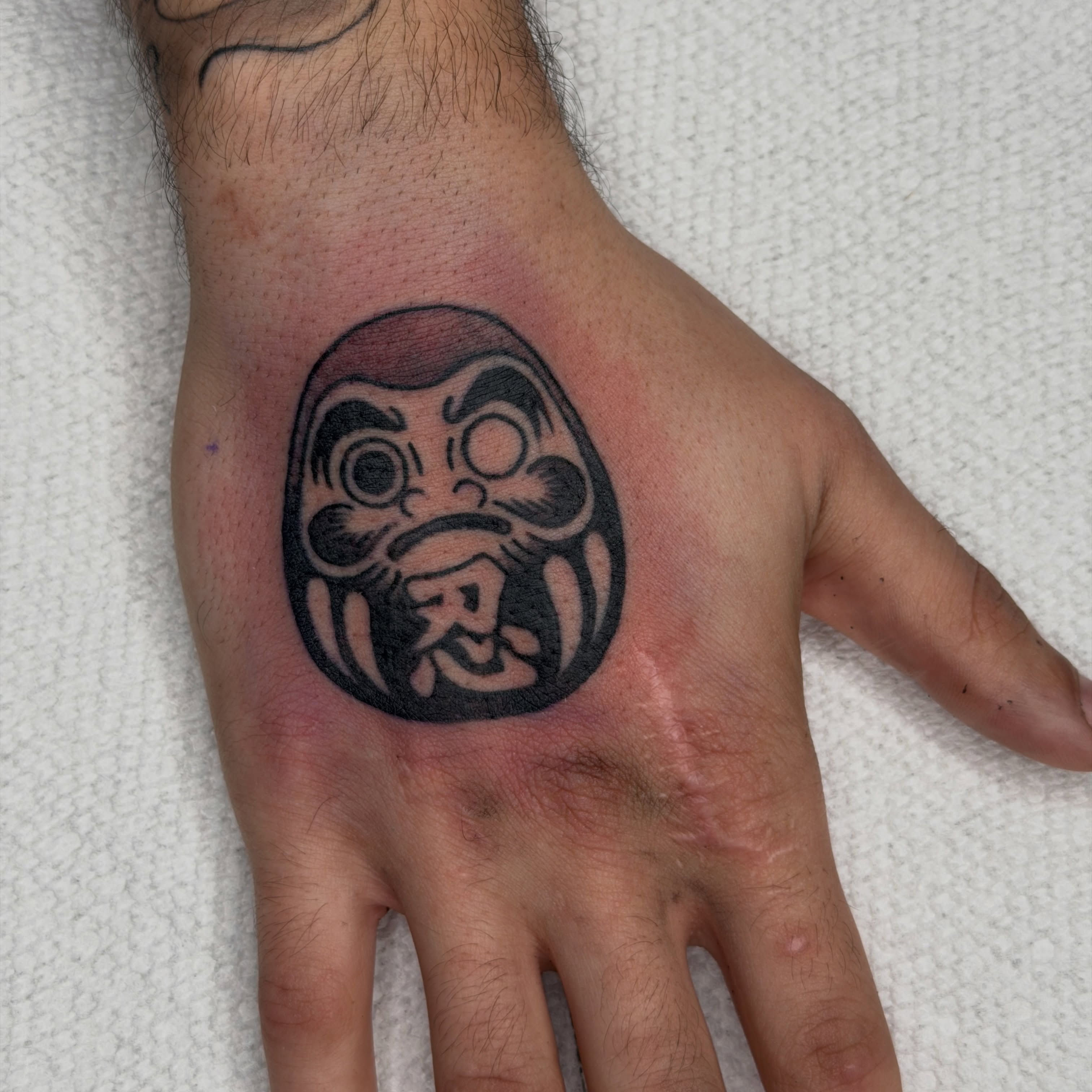 Demon mask black and grey tattoo on the hand by Andrew Storm