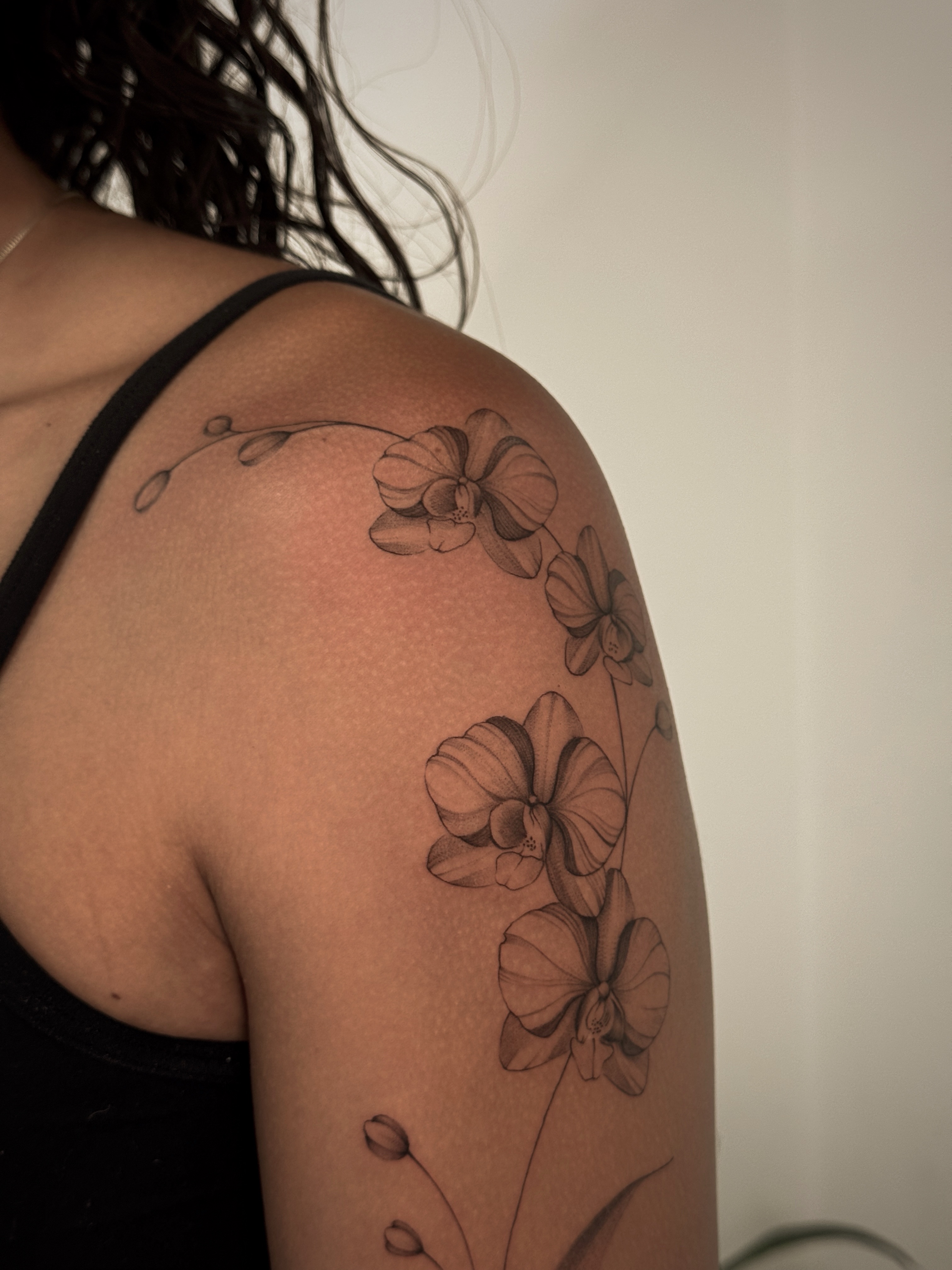 Orchids black and grey tattoo on the shoulder by Gianna Rodriguez