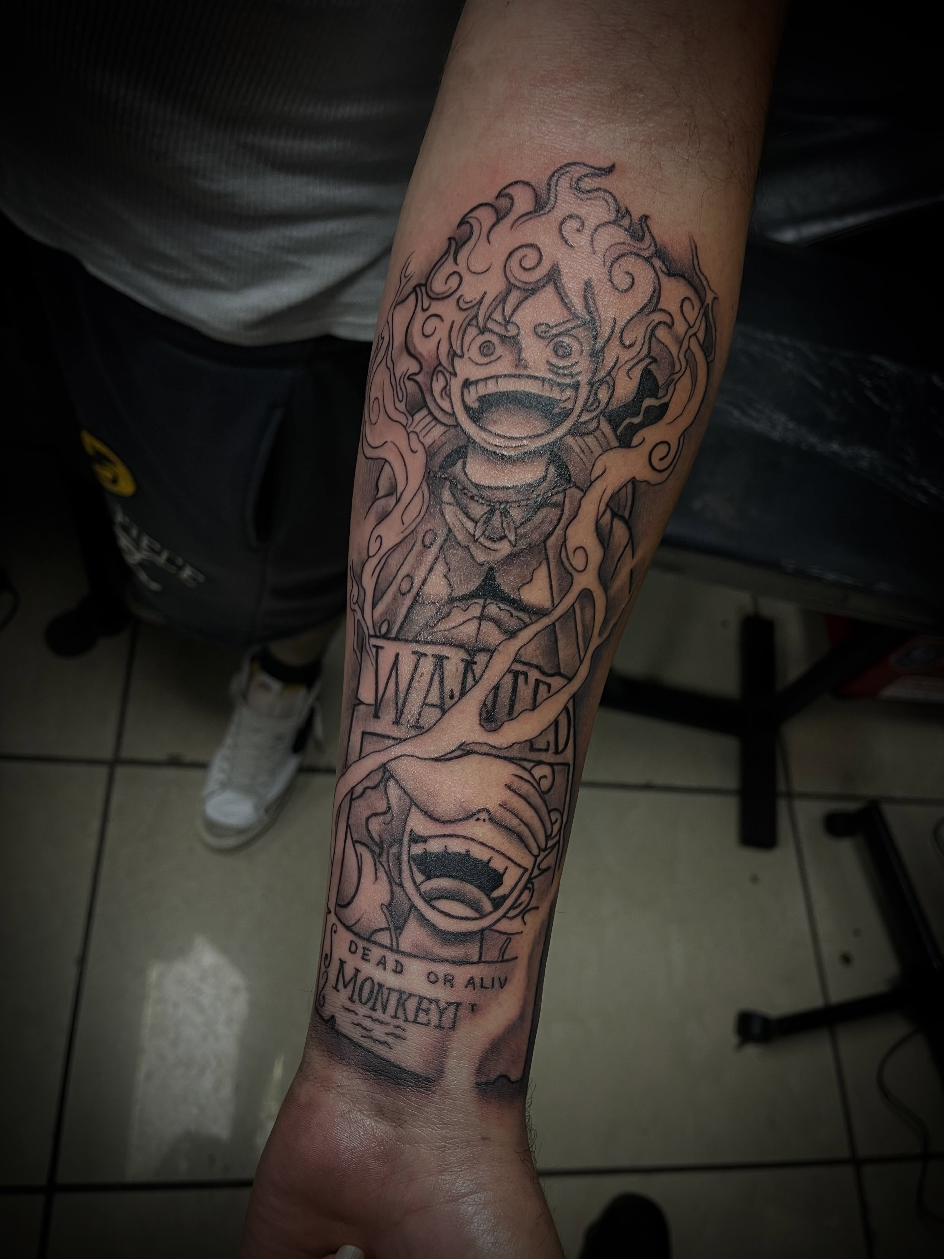 Wanted poster black and grey tattoo on the forearm by Chris Torres