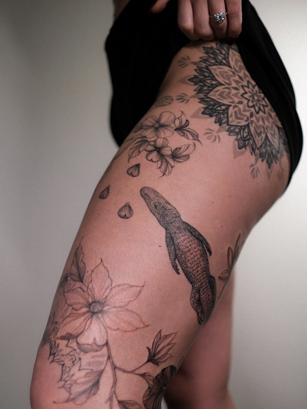 Alligator and flowers black and grey tattoo on the thigh by Temple Adorned Tattoo