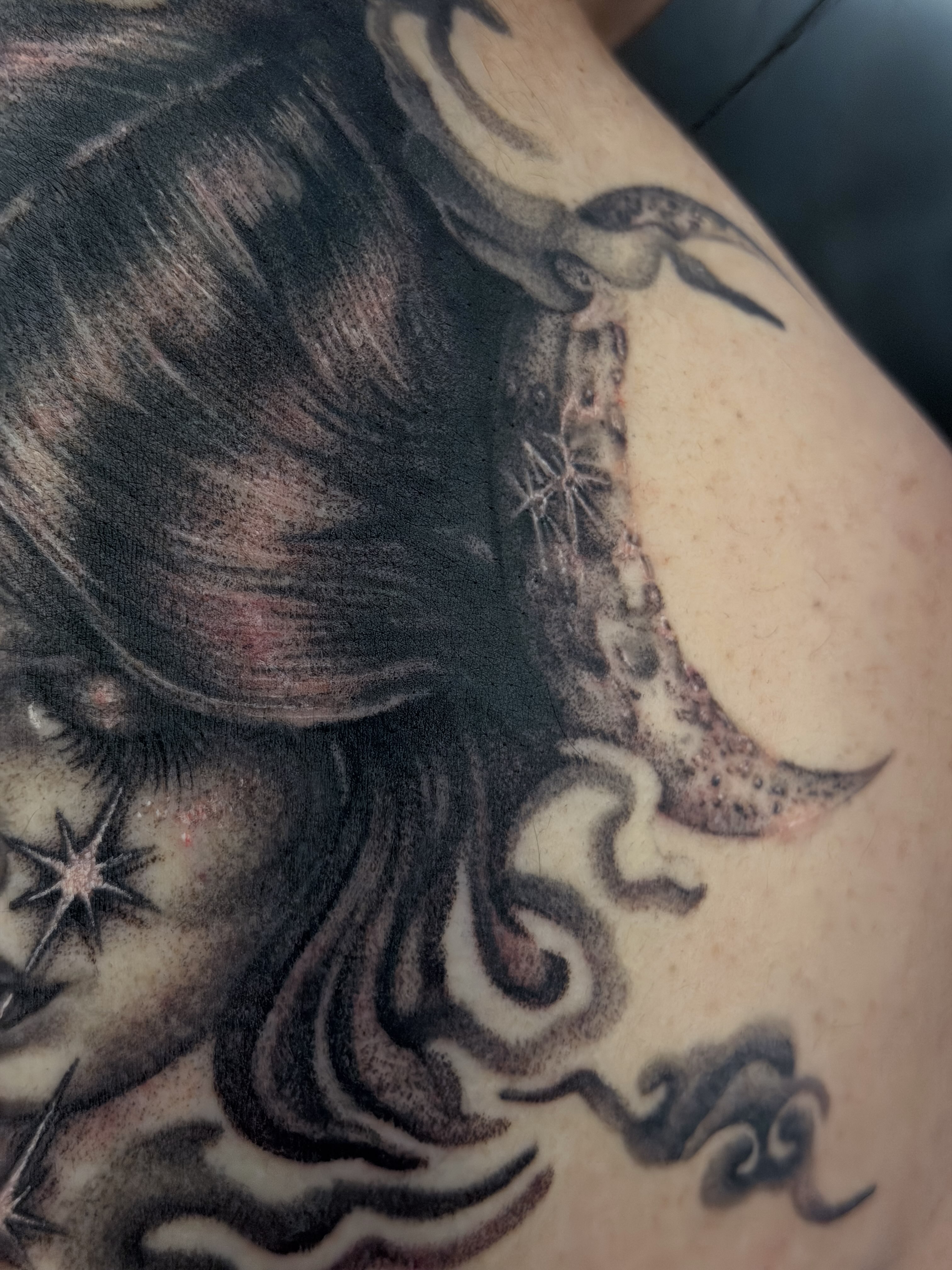 Woman with crescent moon realism tattoo on the upper arm by Yvonne