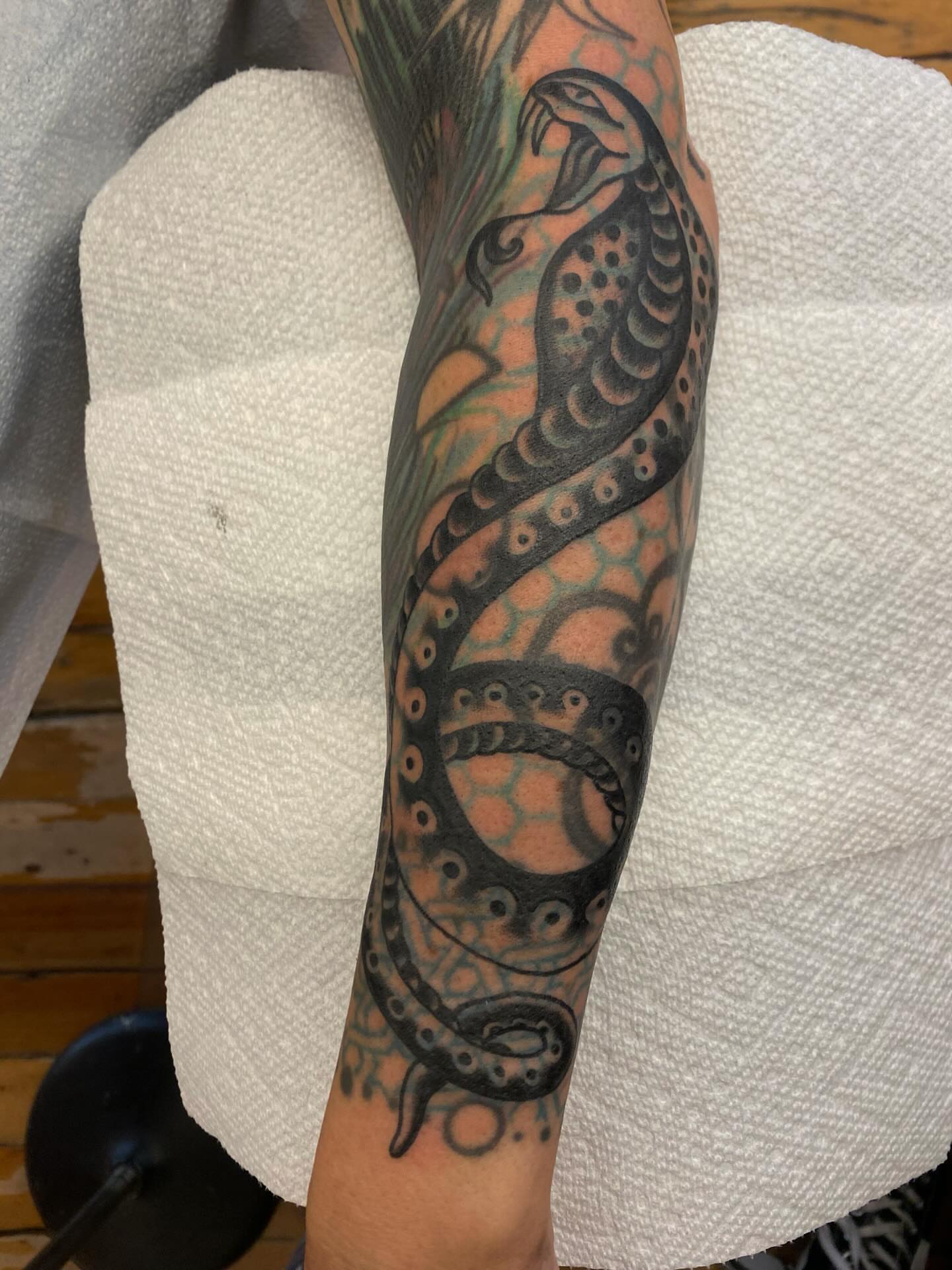 Snake black and grey tattoo on the forearm by Abby Rose Estes
