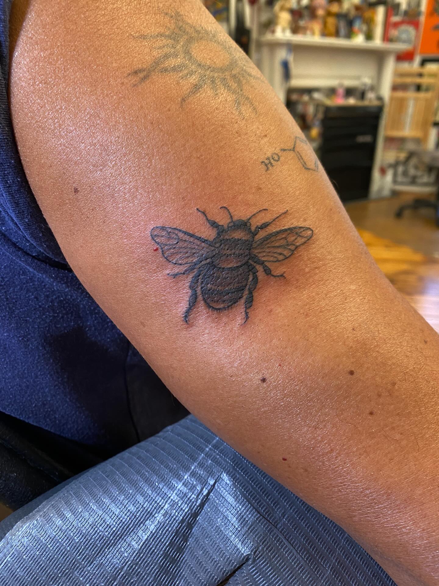 Bee black and grey tattoo on the forearm by Abby Rose Estes