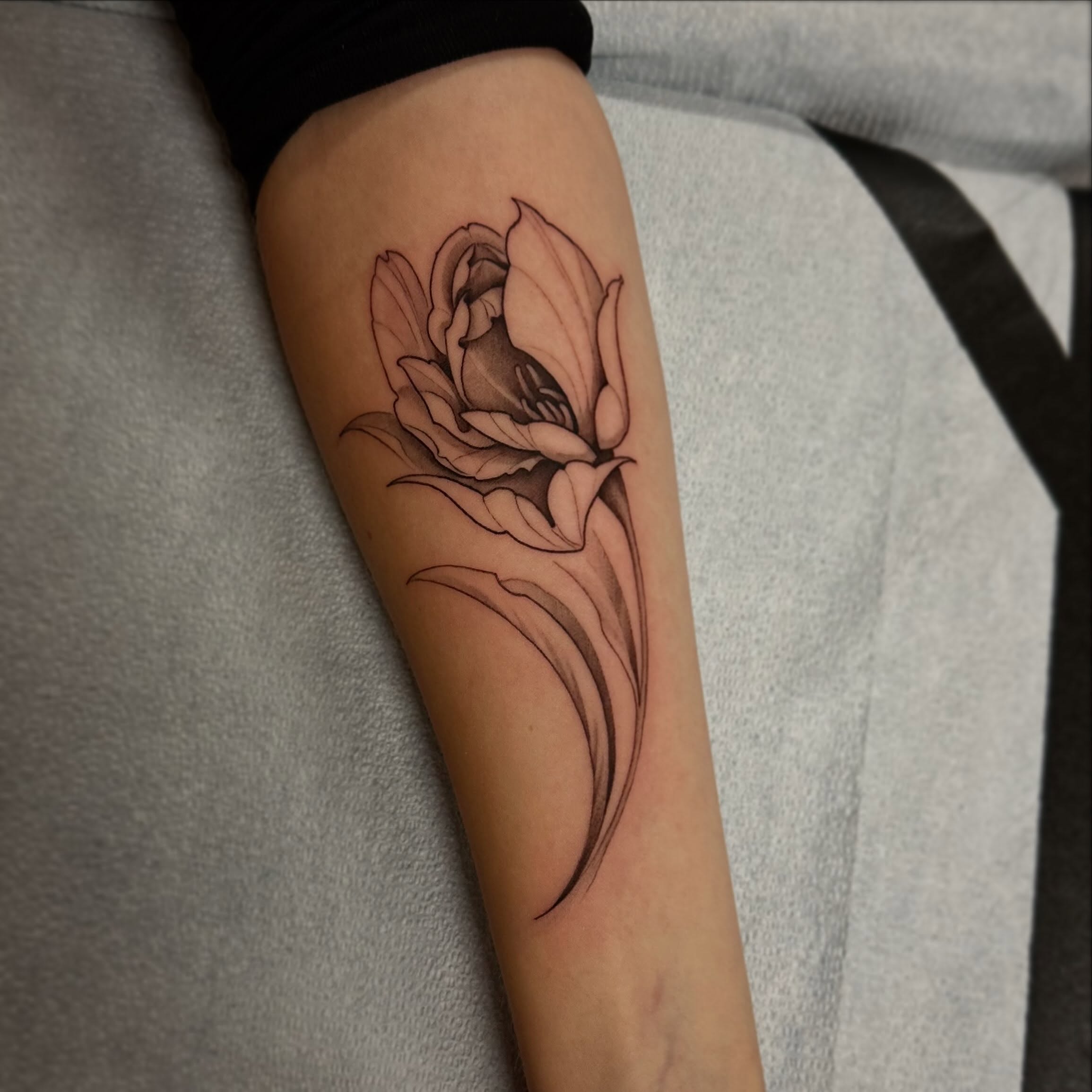 Flower black and grey tattoo on the thigh by Sebastian Livingston