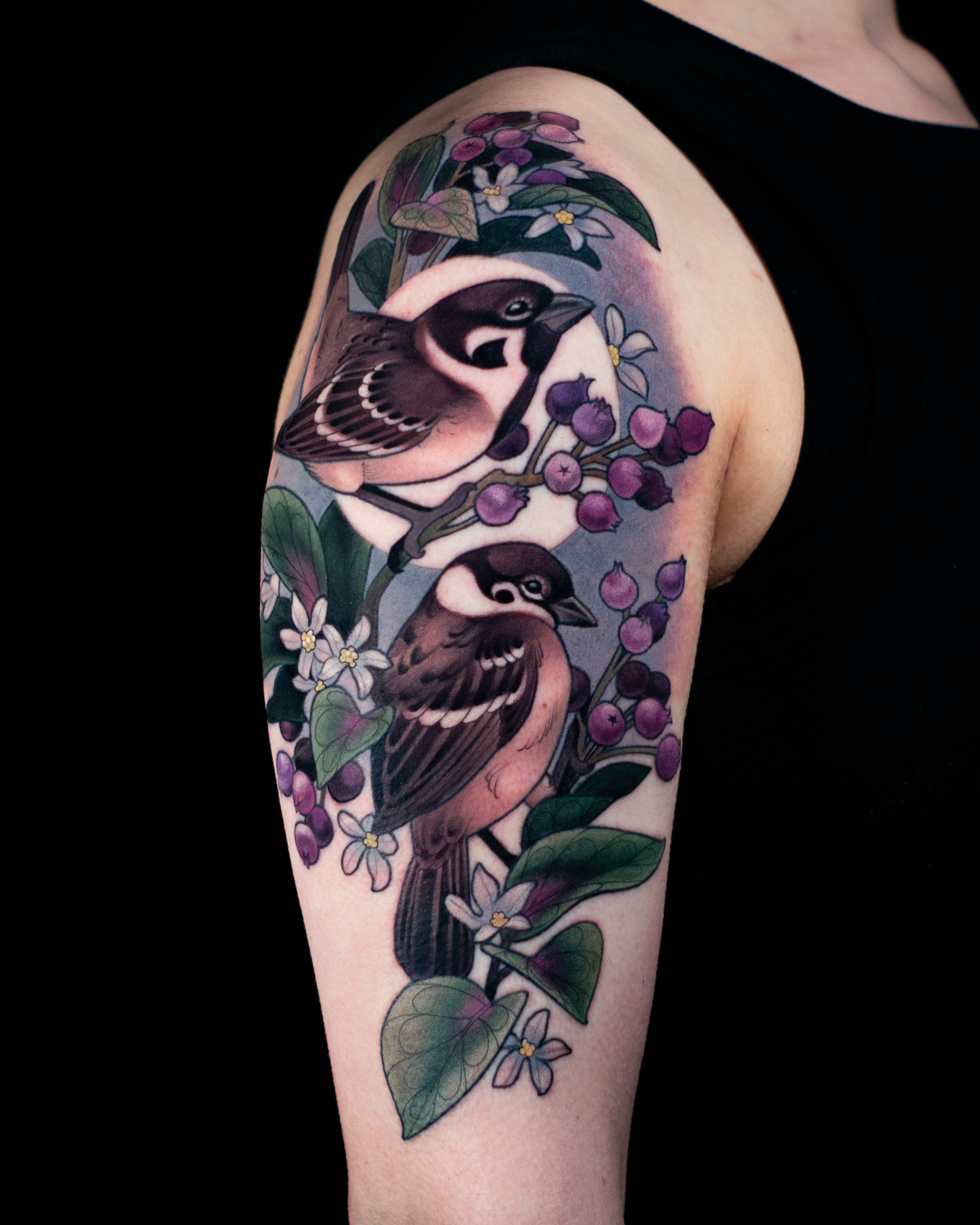 Birds and berries realism tattoo on the upper arm by Hannah Steele
