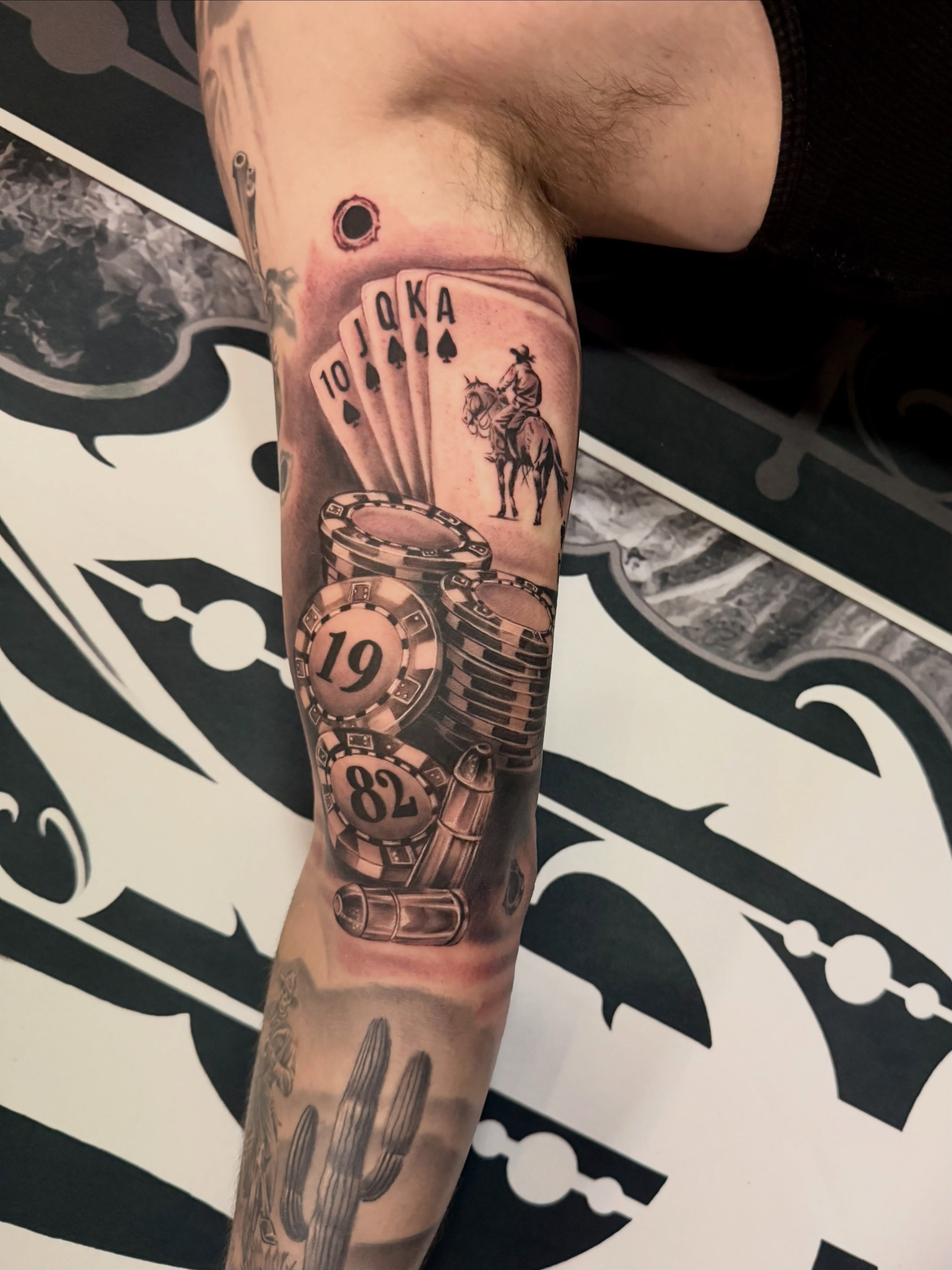 Poker theme realism tattoo on the forearm by Cody Pappas