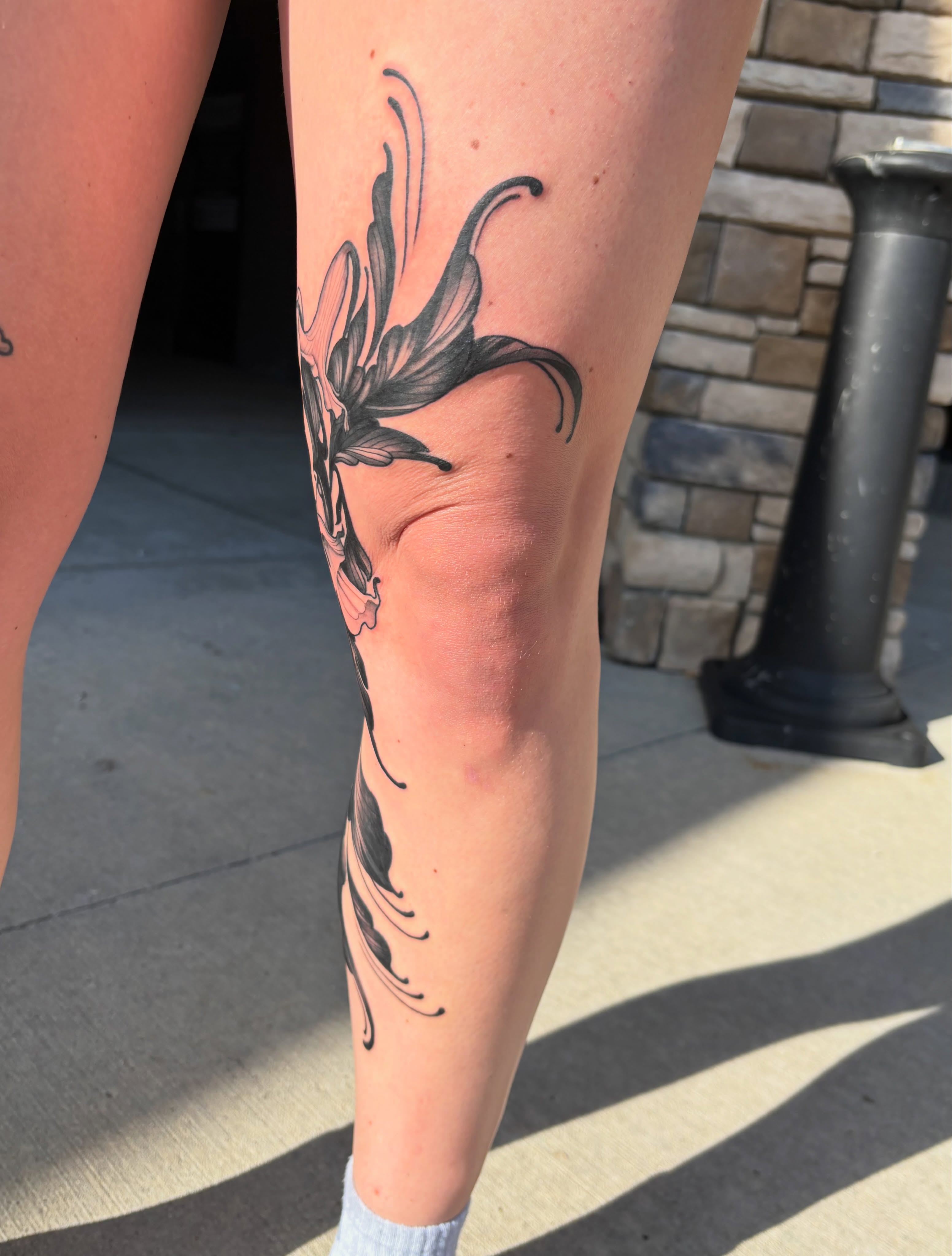 Lily black and grey tattoo on the calf by MJ Saunders