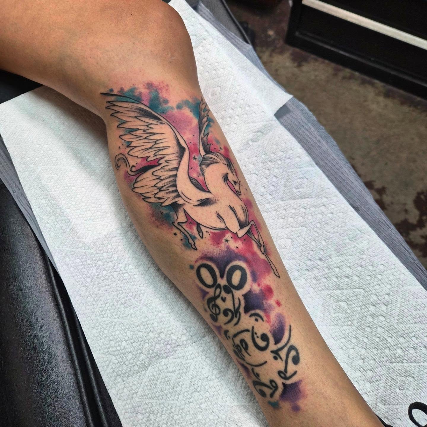 Winged unicorn watercolor tattoo on the forearm by Taylor Popkins