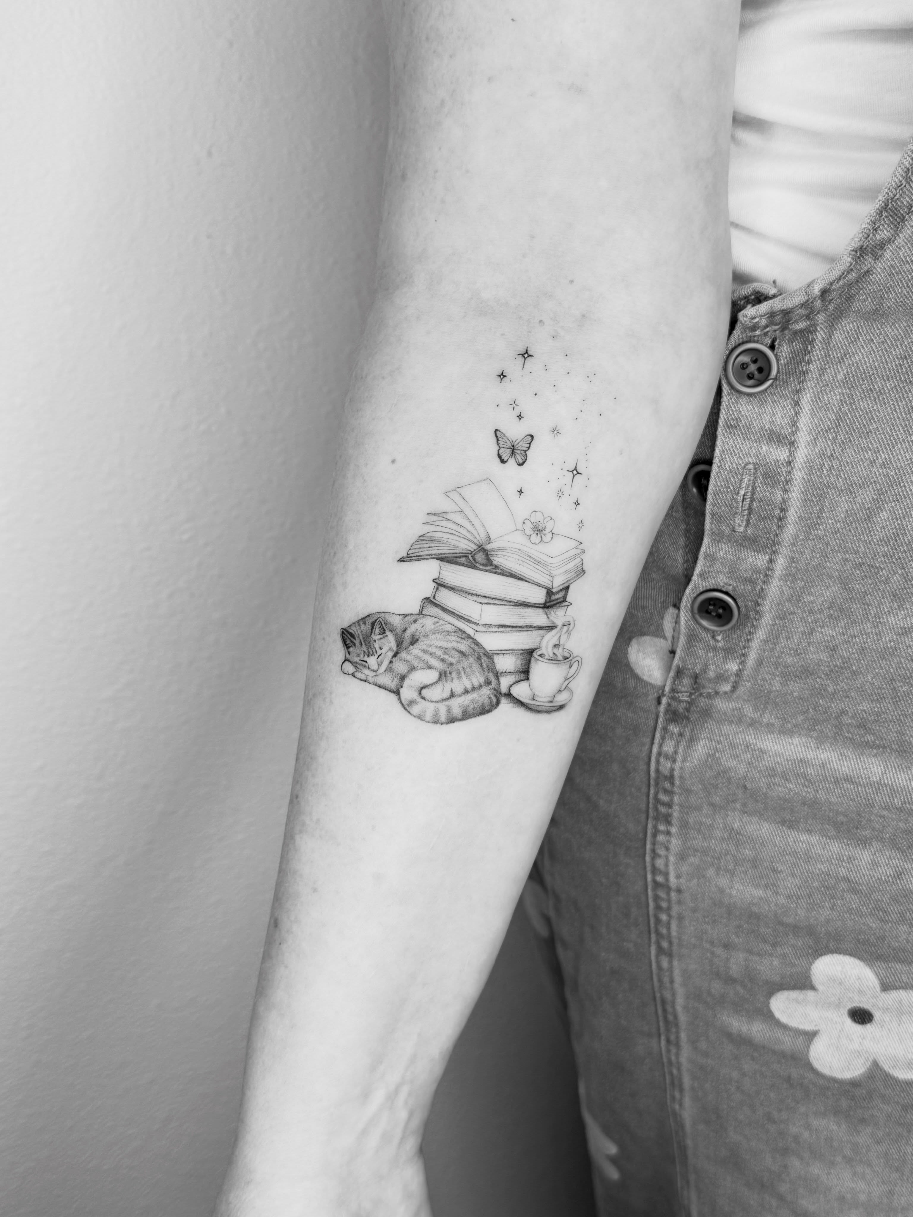 Cat and books realism tattoo on the forearm by Ashley Limon