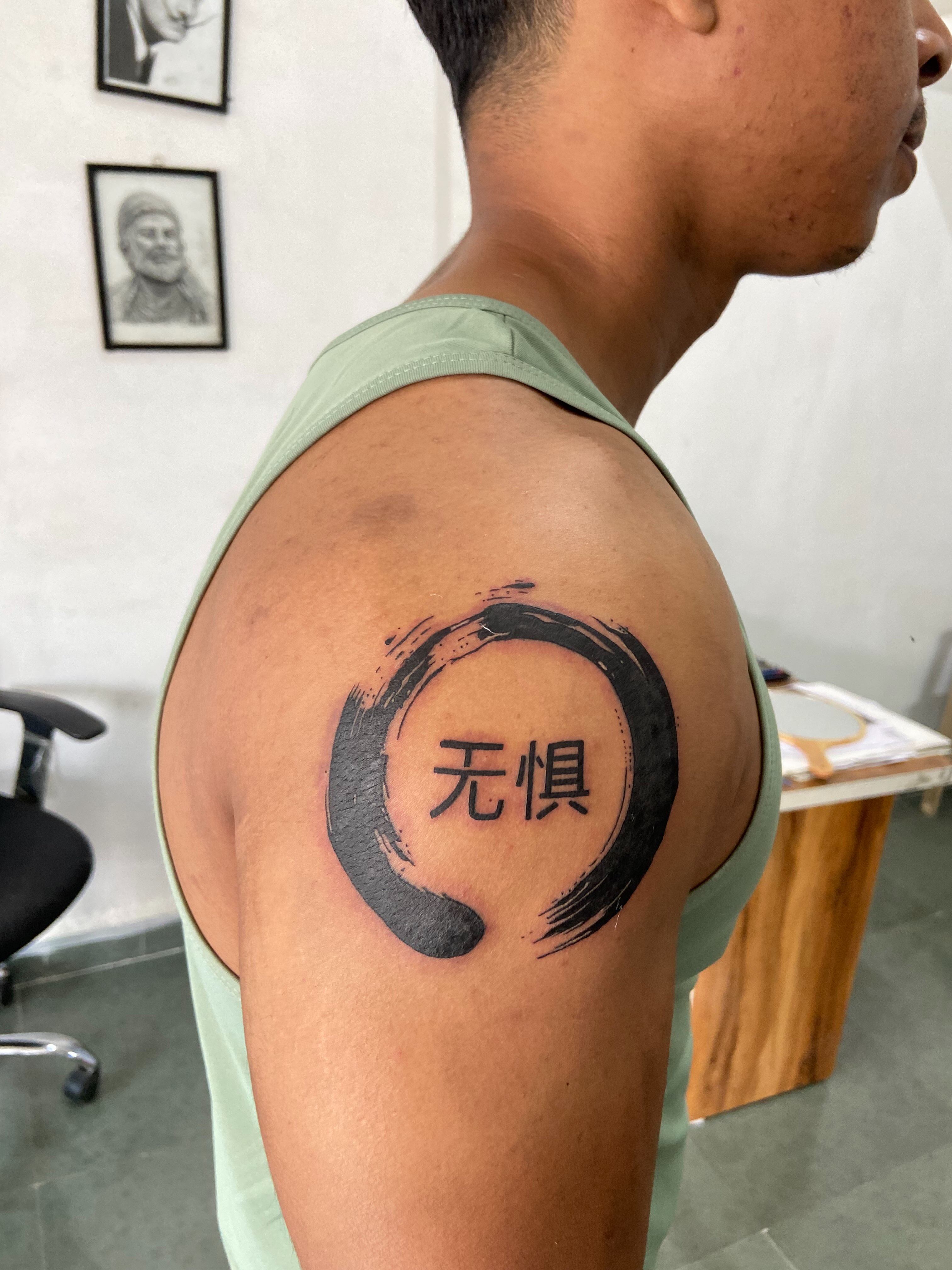 Circle with Chinese characters black and grey tattoo on the shoulder by VR tattoo Studio