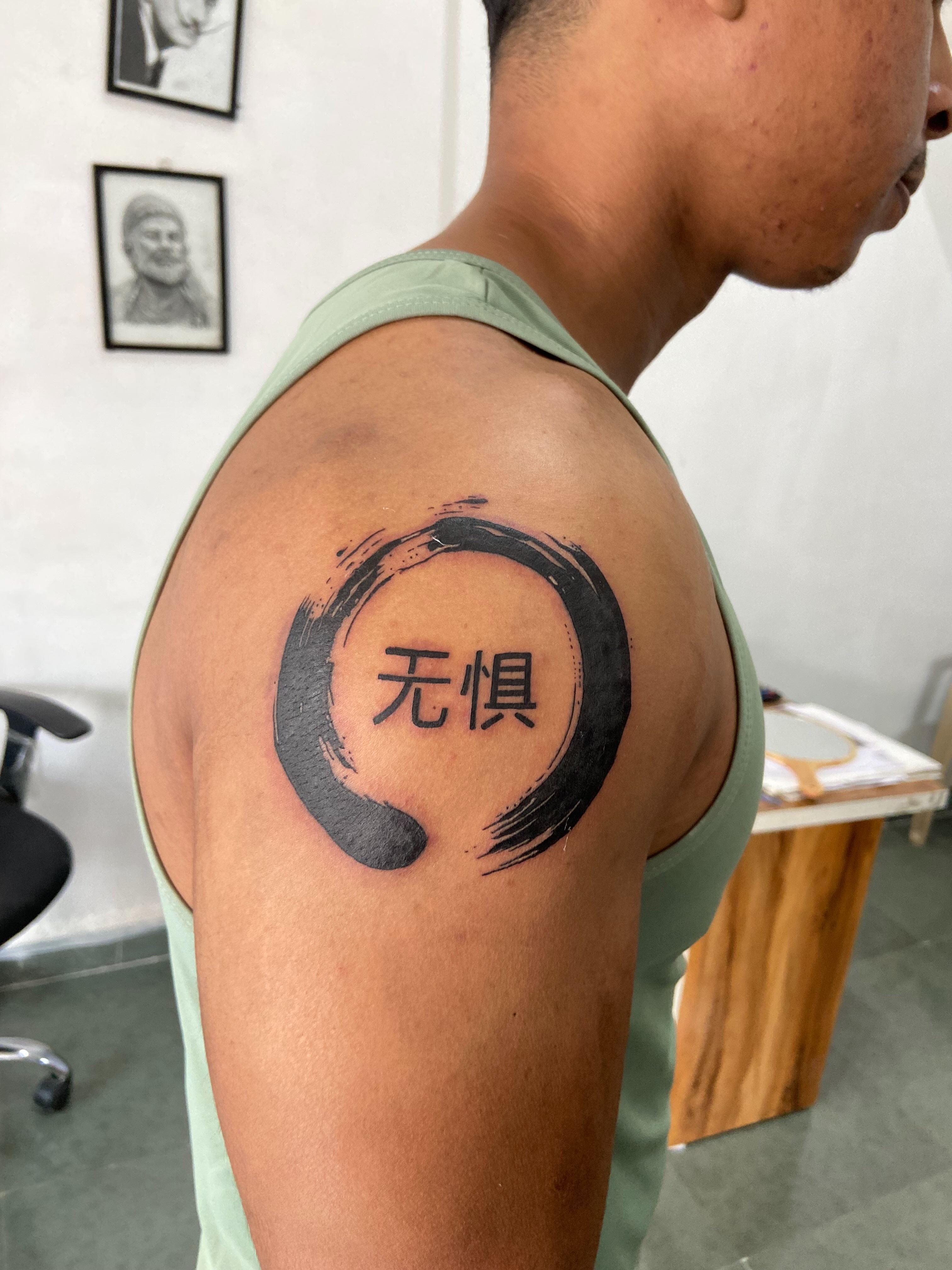 Enso circle with Chinese characters black and grey tattoo on the shoulder by VR tattoo Studio