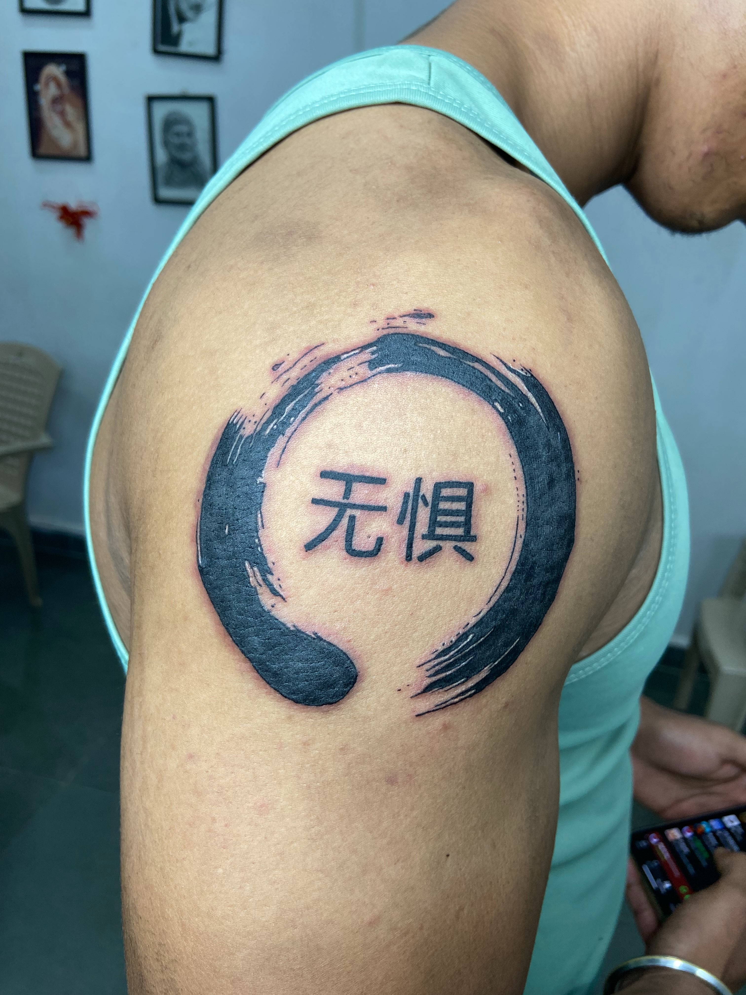 Enso circle with Chinese characters black and grey tattoo on the shoulder by VR tattoo Studio