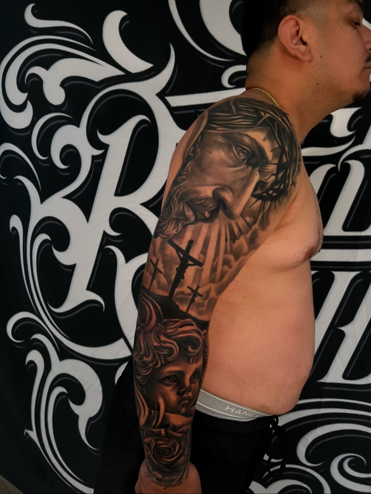 Religious scene realism tattoo on the upper arm by Daniel Michael Perez