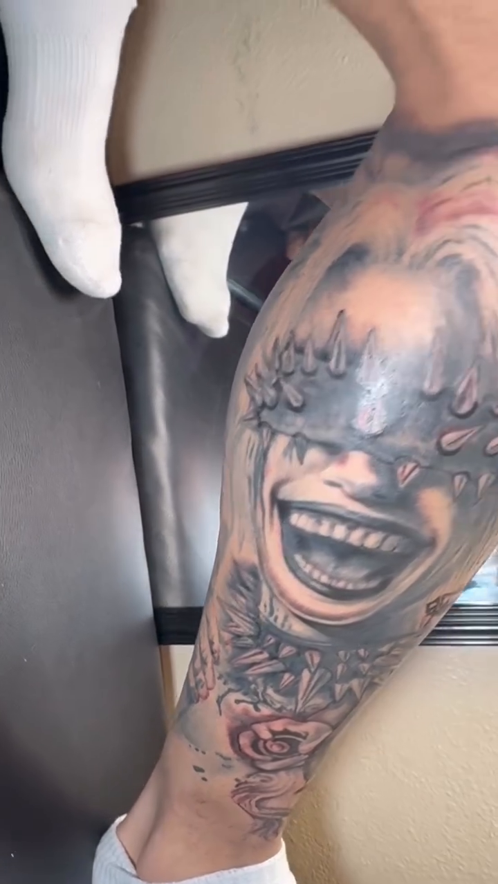 Laughing harlequin face with roses dark realism tattoo by K.L Tattoo Uptown
