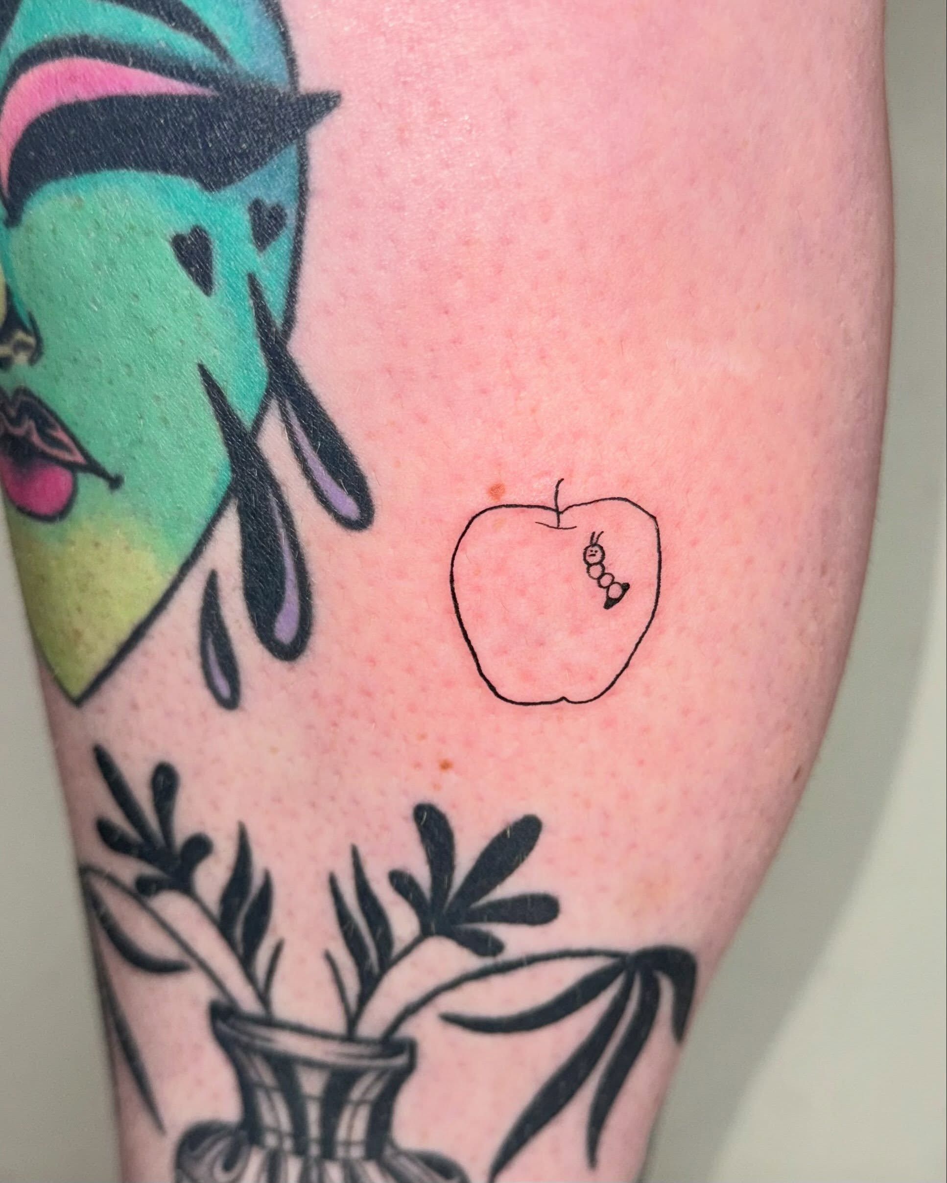Apple with worm minimalist tattoo on the forearm by 림구타투