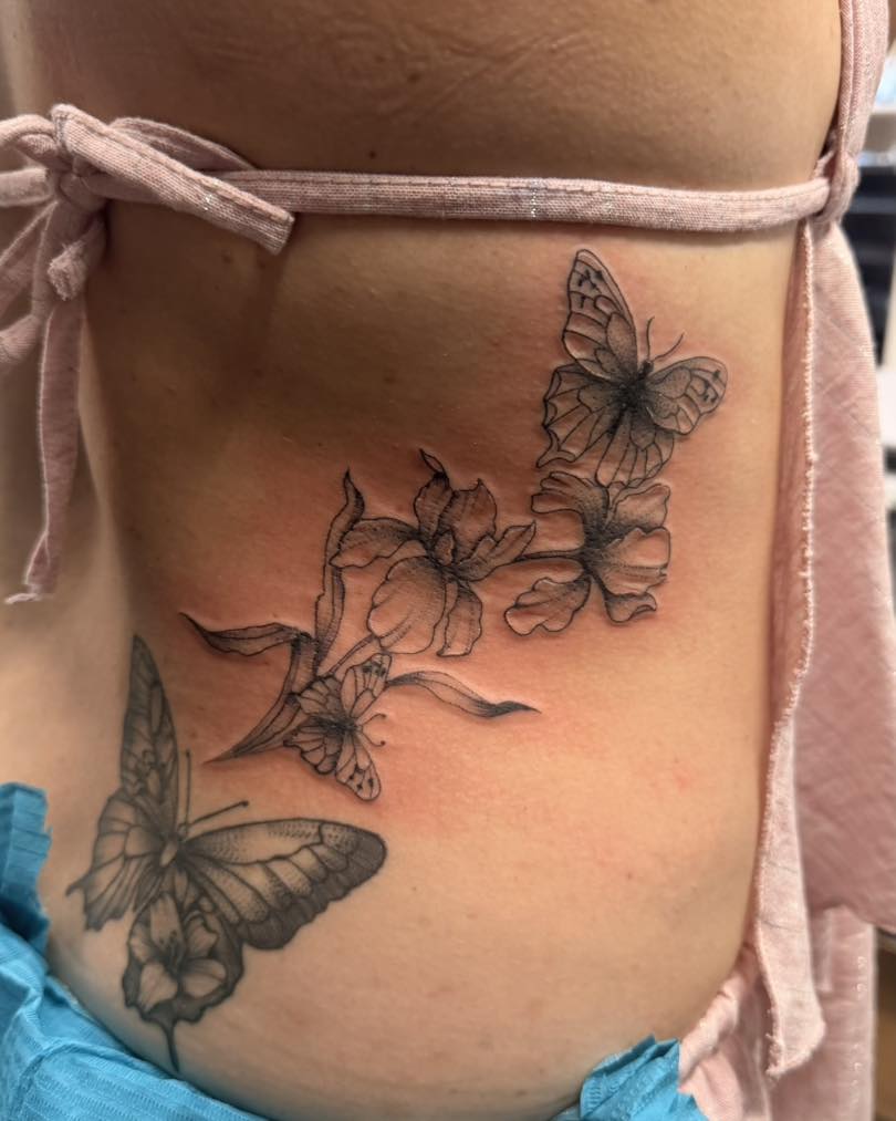 Butterflies and flowers black and grey tattoo on the ribs by Flamboyant