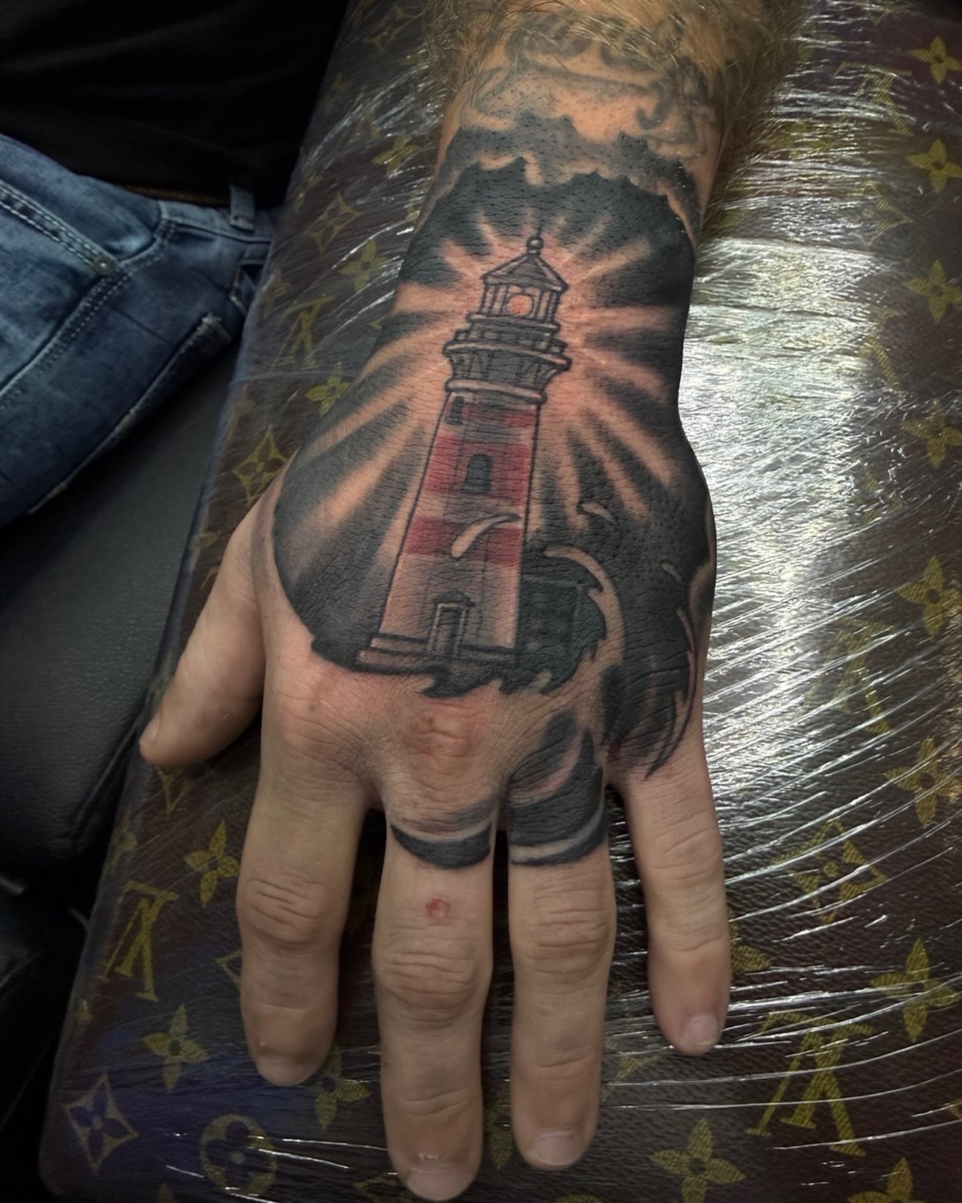 Lighthouse realism tattoo on the hand by Germaine Sherman