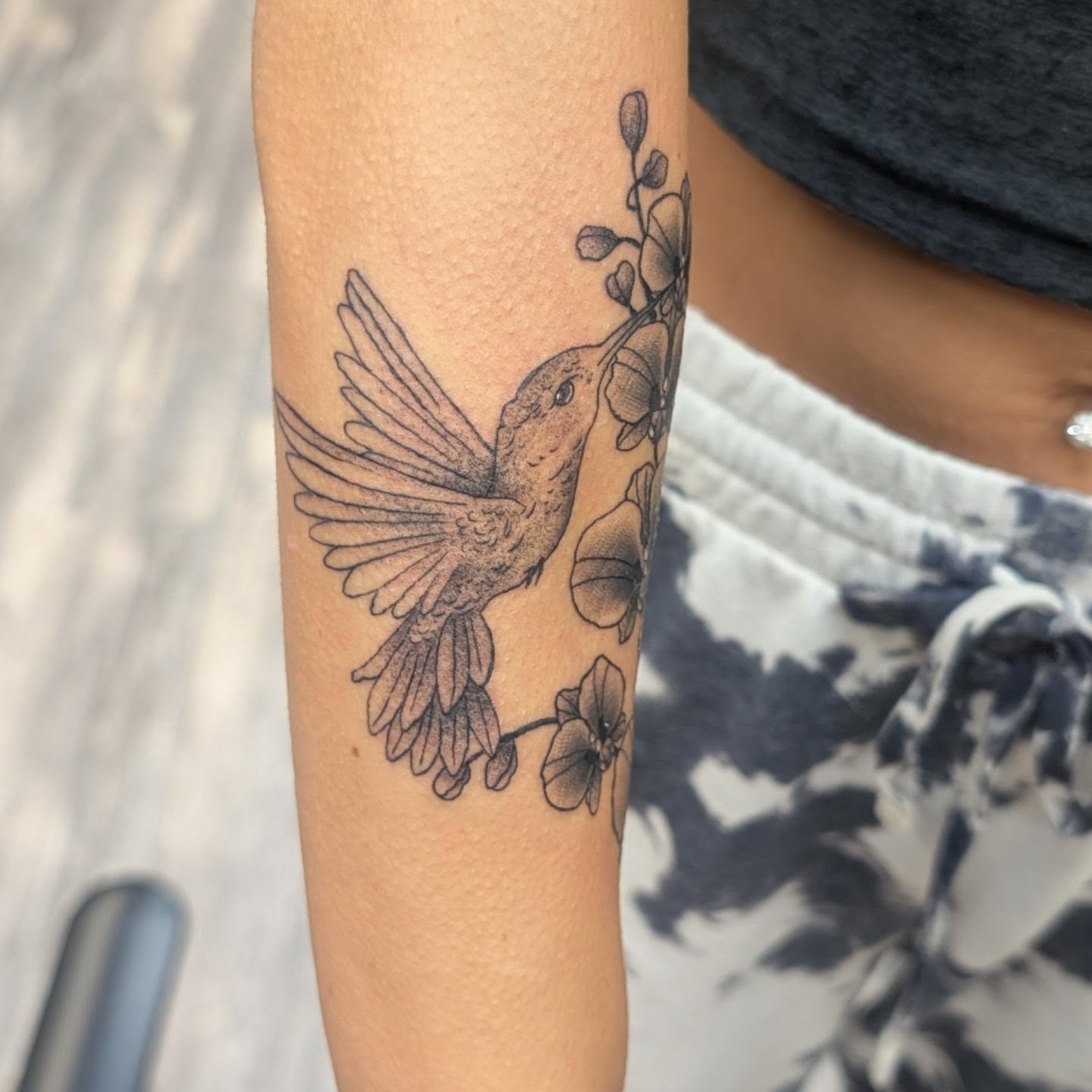 Hummingbird and flowers black and grey tattoo on the forearm by Talia Zula, Loveland, Ohio