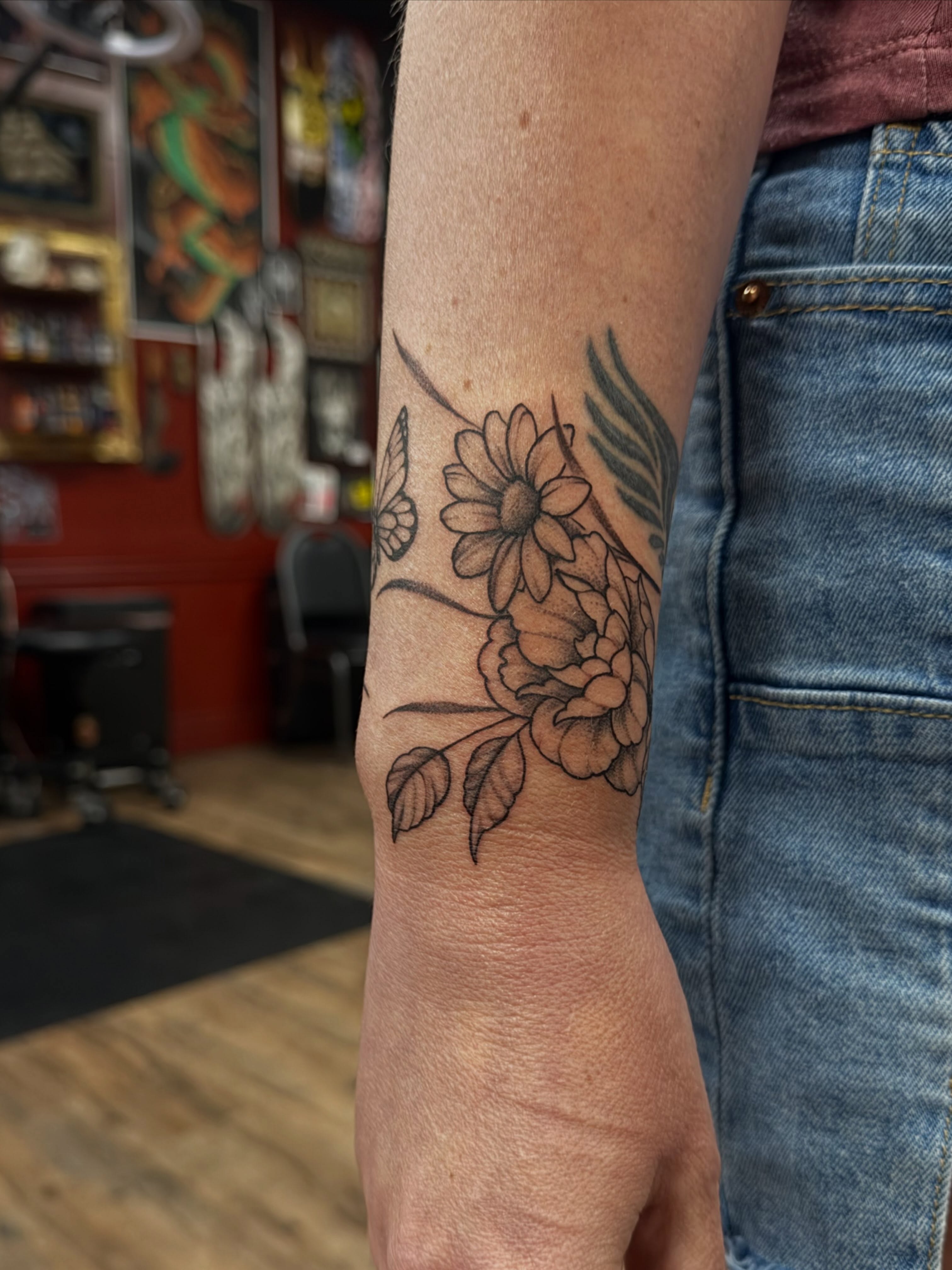 Floral arrangement black and grey tattoo on the forearm by Trista Bettfreund (Birdy)