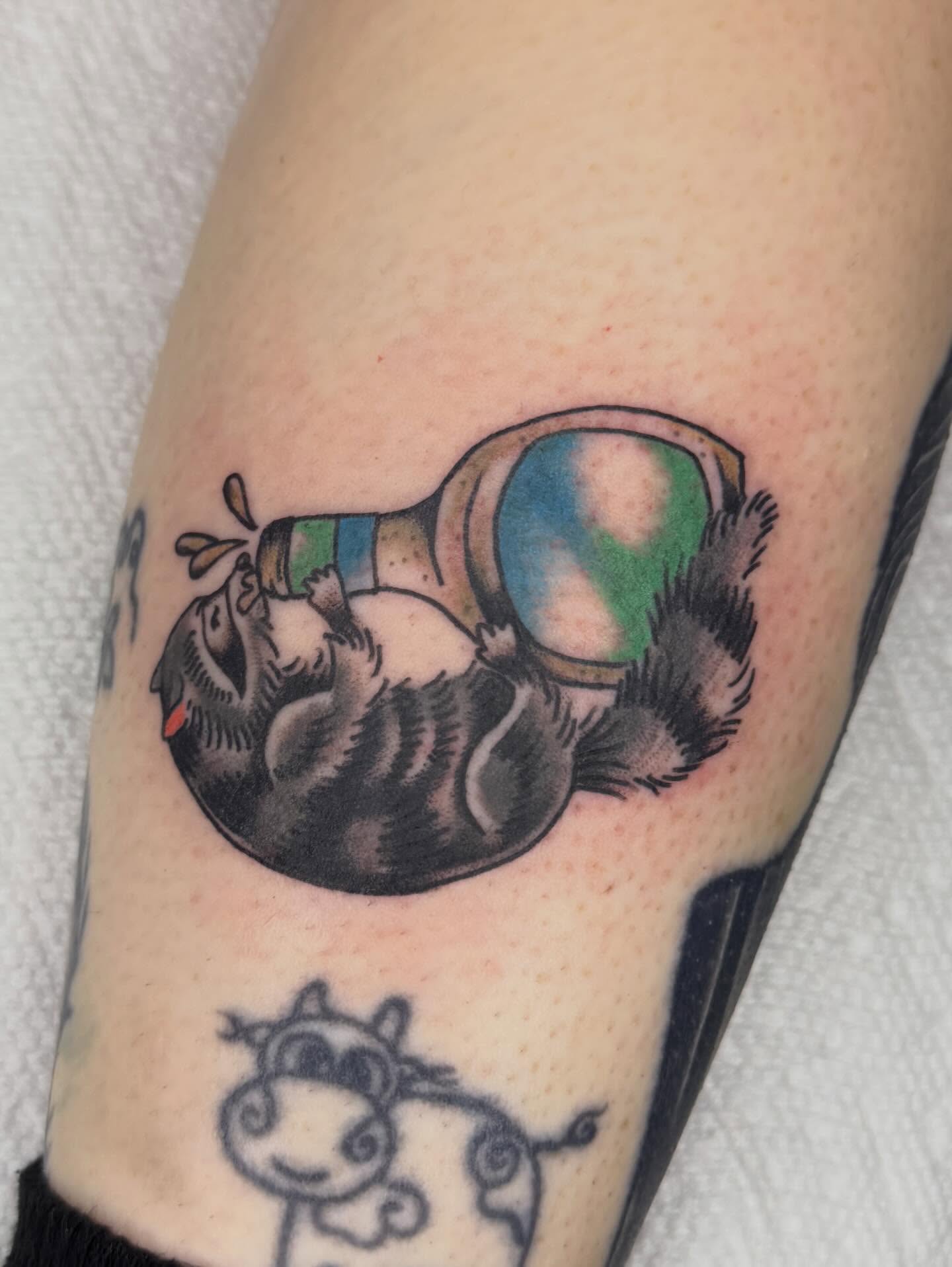 Skunk and magnifying glass American traditional tattoo on the forearm by Jenna Szerszen-Wynn ๐