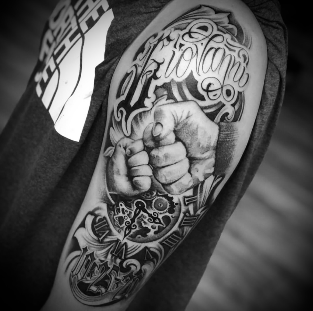 Fist and lettering realism tattoo on the forearm by Big Steve Lewis