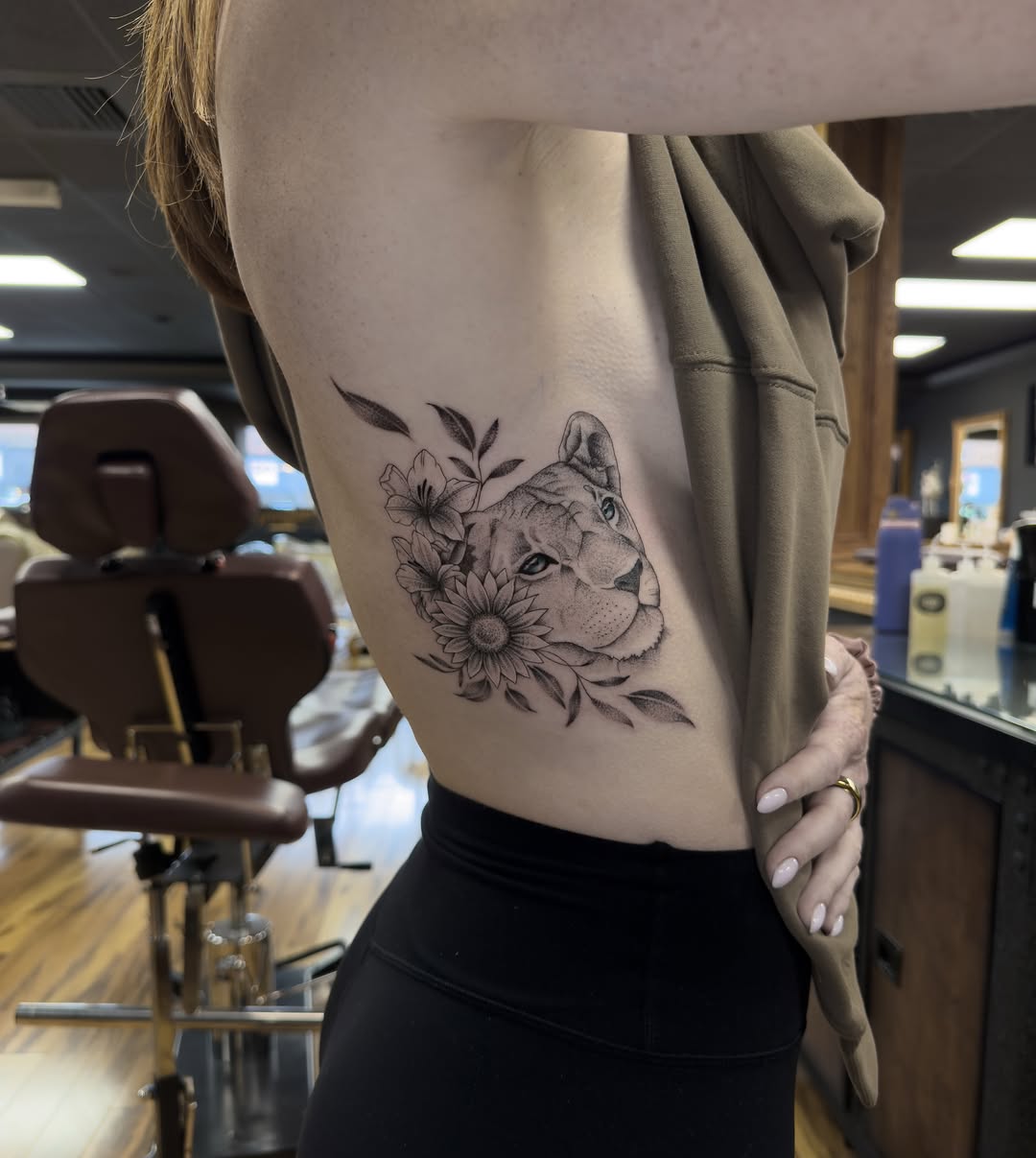 Lioness with flowers realism tattoo on the ribs by Leo Fernandes, Danvers, Massachusetts