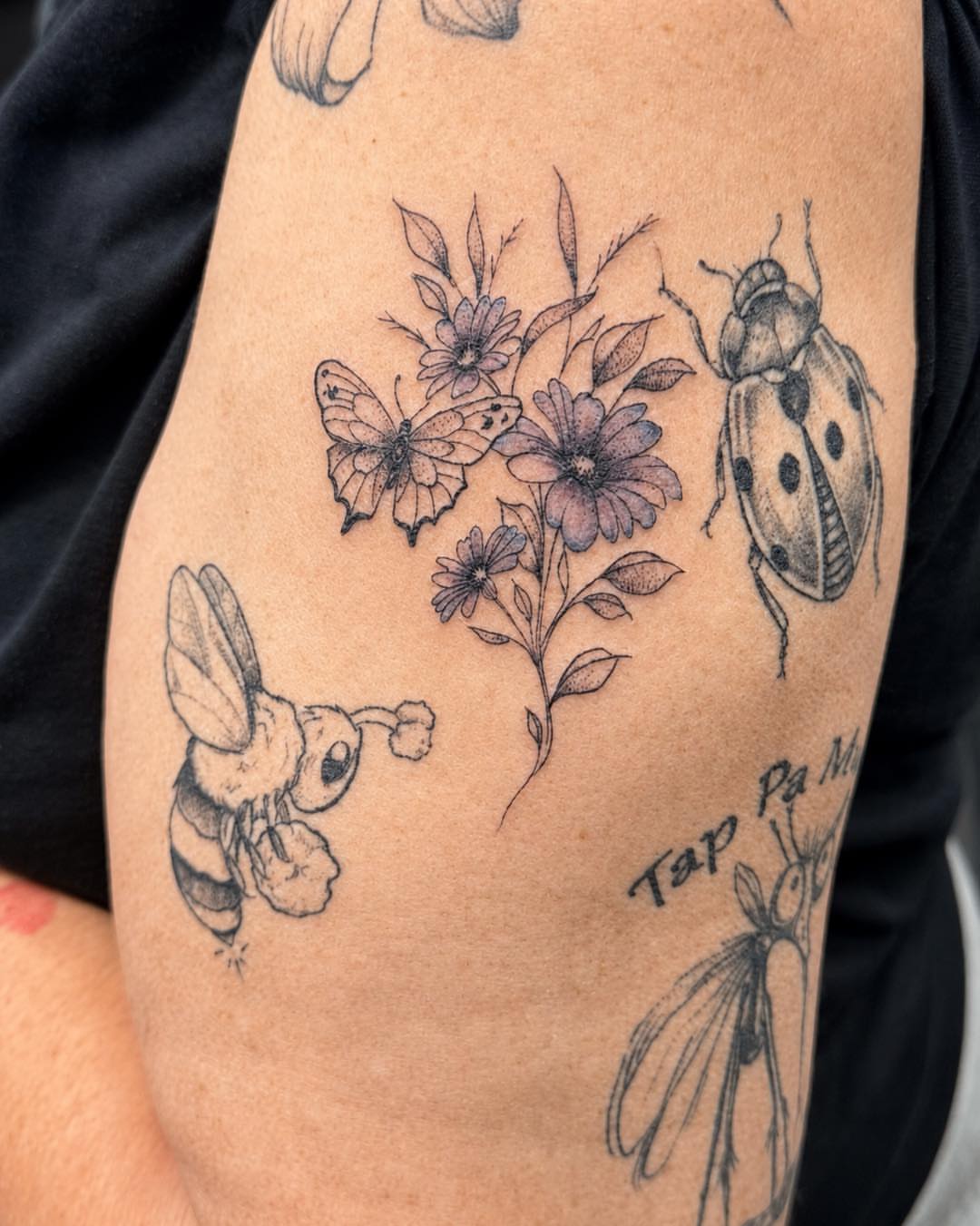 Flowers and insects black and grey tattoo on the forearm by Flamboyant