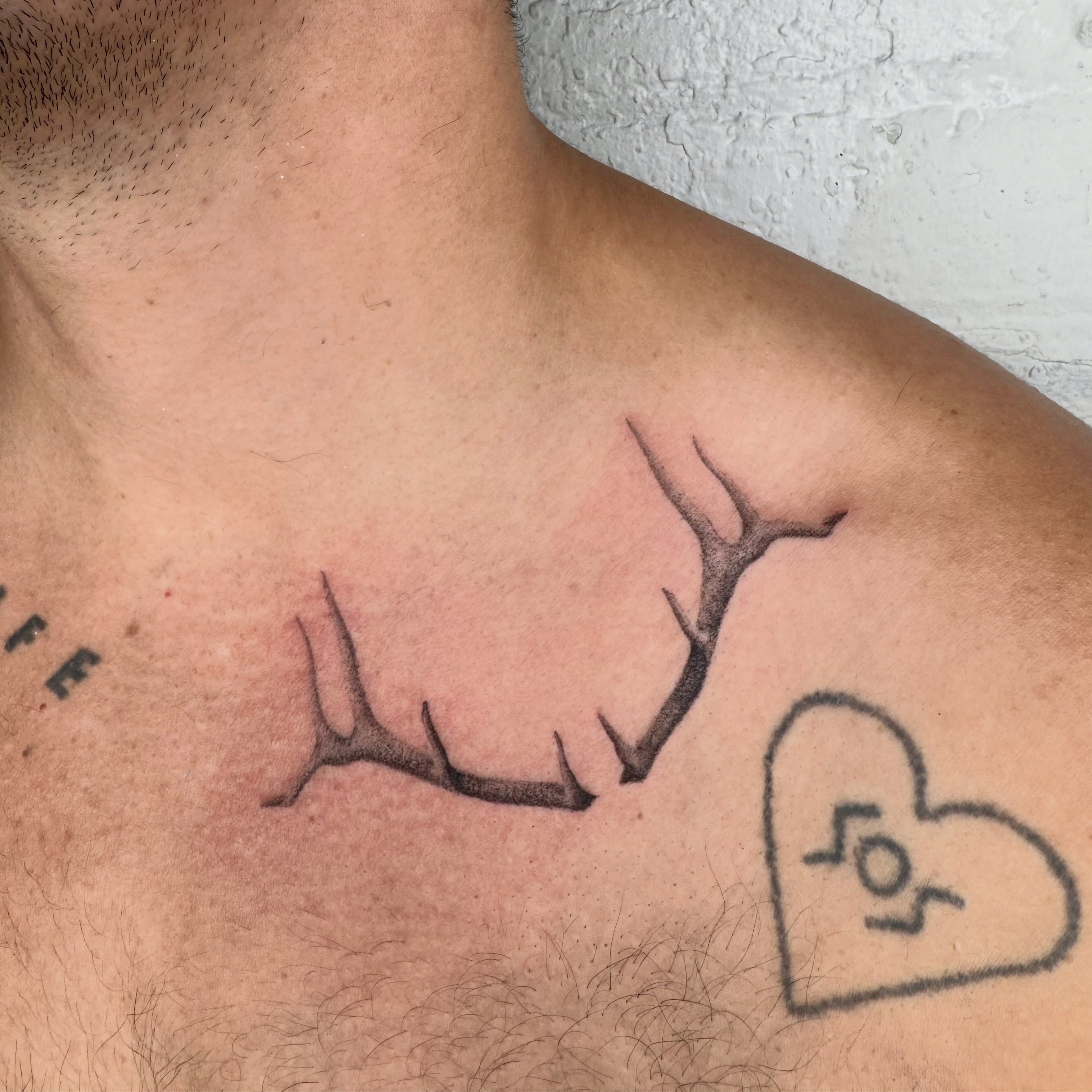 Antlers and heart black and grey tattoo on the chest by Kenny ๐ด