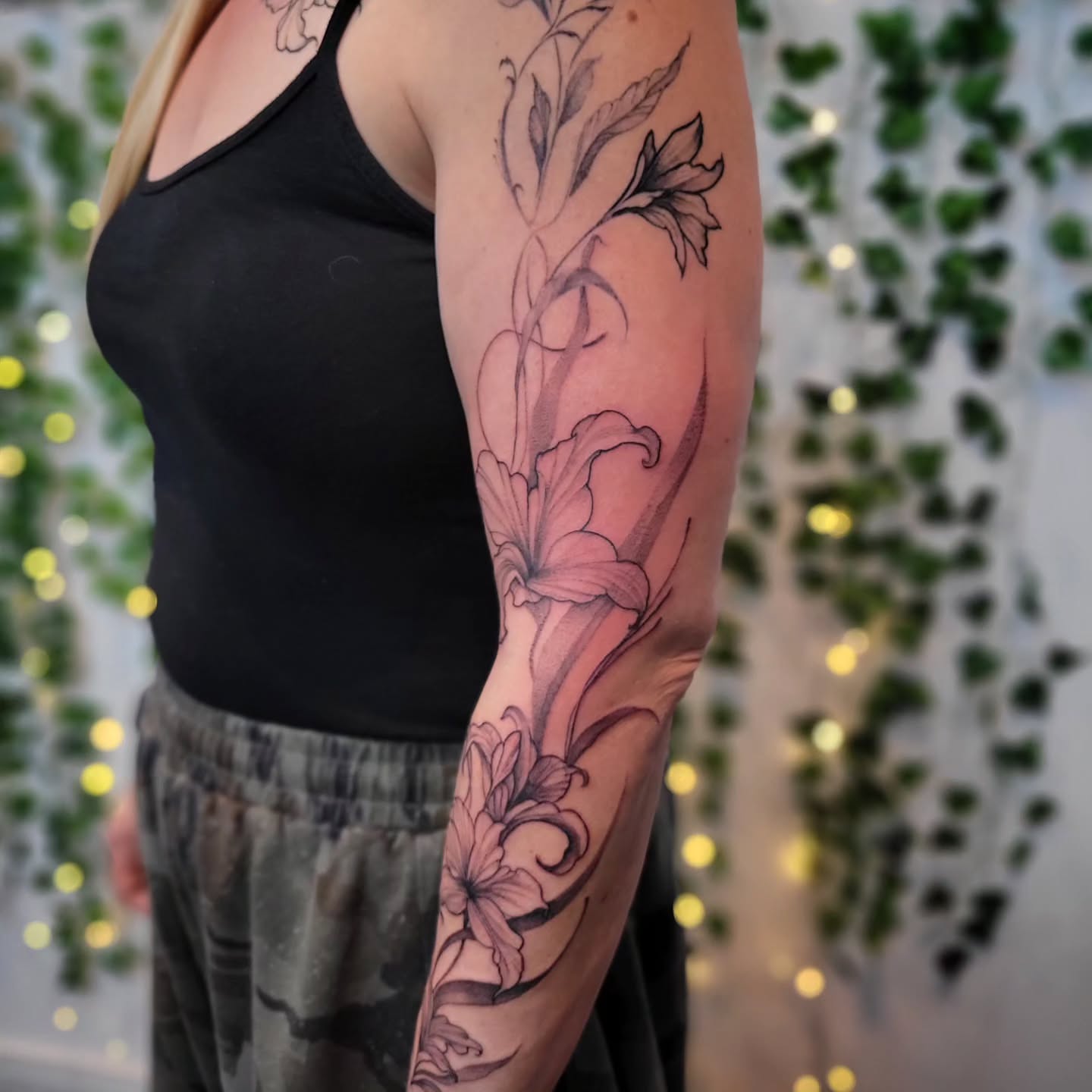 Lily black and grey tattoo on the forearm by Uku Tattoos, Cambridge, England