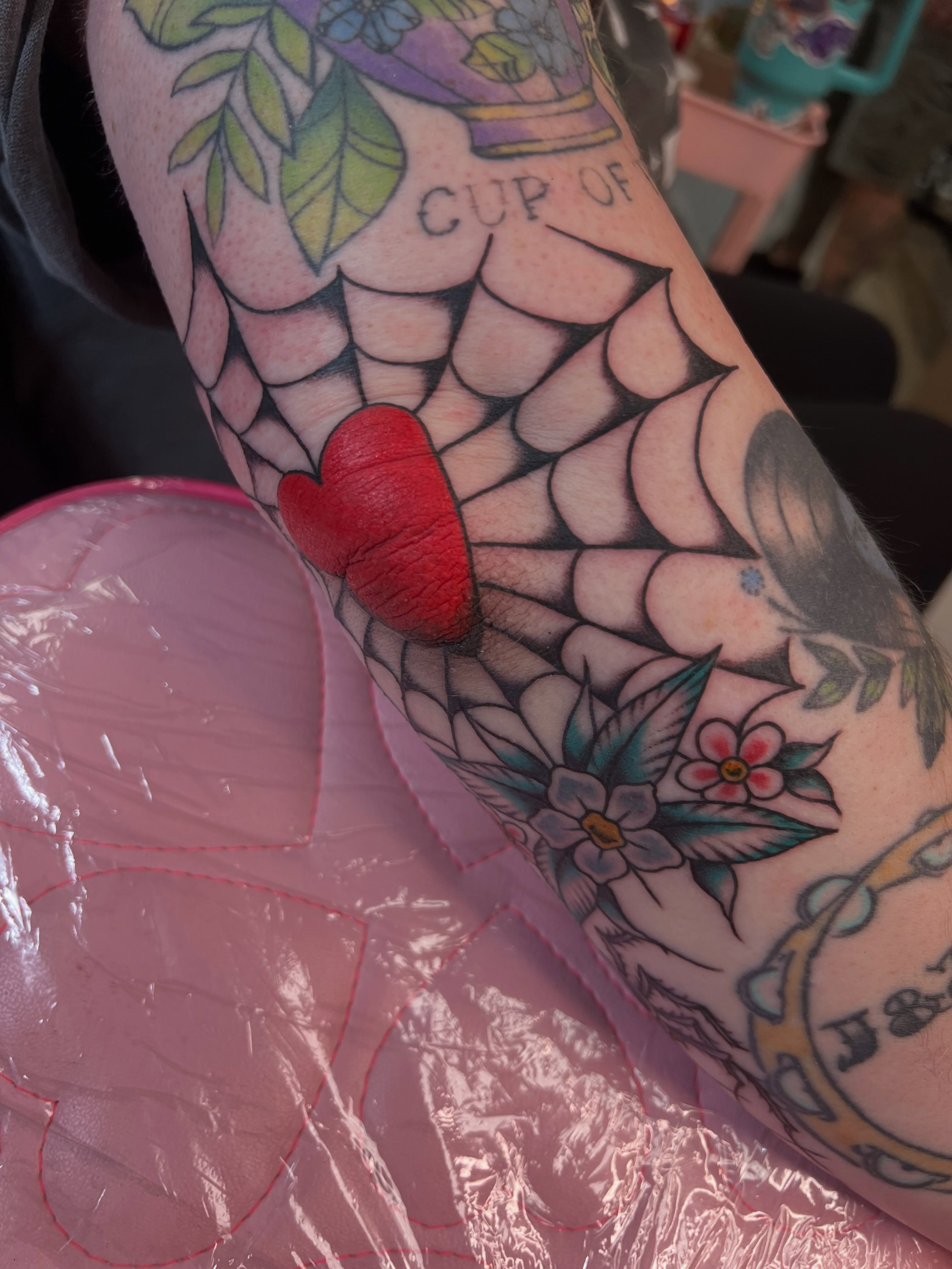 Heart and spiderweb American traditional tattoo on the forearm by Emily Queen