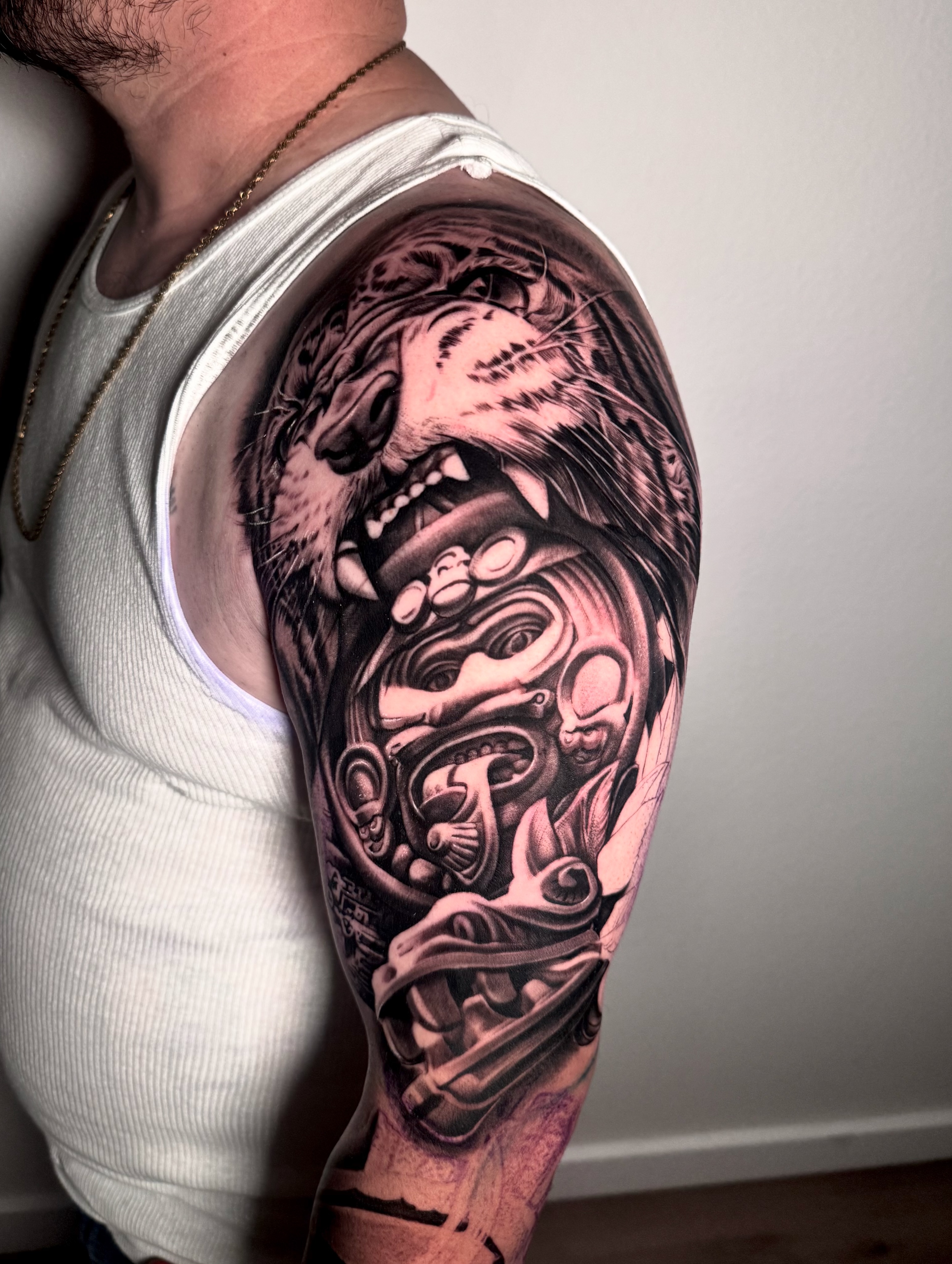 Wolf and mask realism tattoo on the upper arm by Yudel